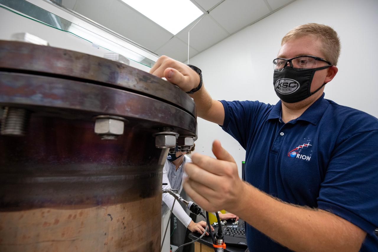 Evan Bell, a mechanical engineer and member of the Gaseous Lunar Oxygen from Regolith Electrolysis (GaLORE) project team at NASA’s Kennedy Space Center in Florida, checks the hardware that will be used to melt lunar regolith – dirt and dust on the Moon made from crushed rock – simulants during a test inside a laboratory at Kennedy’s Neil Armstrong Operations and Checkout Building on Oct. 29, 2020. GaLORE was selected as an Early Career Initiative project by the agency’s Space Technology Mission directorate, and the team was tasked with developing a device that could melt lunar regolith and turn it into oxygen. As NASA prepares to land the first woman and the next man on the Moon in 2024 as part of the Artemis program, technology such as this can assist with sustainable human lunar exploration and long-duration missions to Mars.  