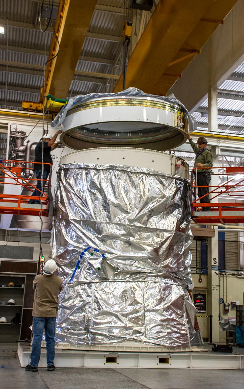 Inside Building 7525, a processing facility at Vandenberg Space Force Base in California, workers assist as the aft stub adapter is lowered onto the interstage adapter for the United Launch Alliance Atlas V rocket on Nov. 4, 2020. The Atlas V will launch NASA’s Landsat 9 satellite from Vandenberg in September 2021. The launch is being managed by NASA’s Launch Services Program based at Kennedy Space Center. Landsat 9 will continue the nearly 50-year legacy of previous Landsat missions. It will monitor key natural and economic resources from orbit. Landsat 9 is managed by the agency’s Goddard Space Flight Center in Greenbelt, Maryland. It will carry two instruments: the Operational Land Imager 2, which collects images of Earth’s landscapes in visible, near infrared and shortwave infrared light, and the Thermal Infrared Sensor 2, which measures the temperature of land surfaces. Like its predecessors, Landsat 9 is a joint mission between NASA and the U.S. Geological Survey.