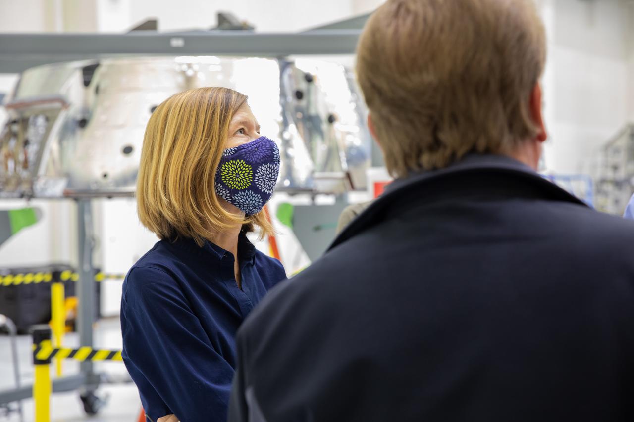 Kathy Lueders, associate administrator of NASA’s Human Exploration and Operations Mission Directorate, visits the Neil Armstrong Operations and Checkout Building high bay at the agency’s Kennedy Space Center in Florida on Nov. 5, 2020. In the background is the Orion spacecraft’s forward bay cover for Artemis I. The first in a series of increasingly complex missions, Artemis I will test the Space Launch System rocket and Orion spacecraft as an integrated system prior to crewed flights to the Moon. Under the Artemis program, NASA is planning to land the first woman and the next man on the lunar surface by 2024.