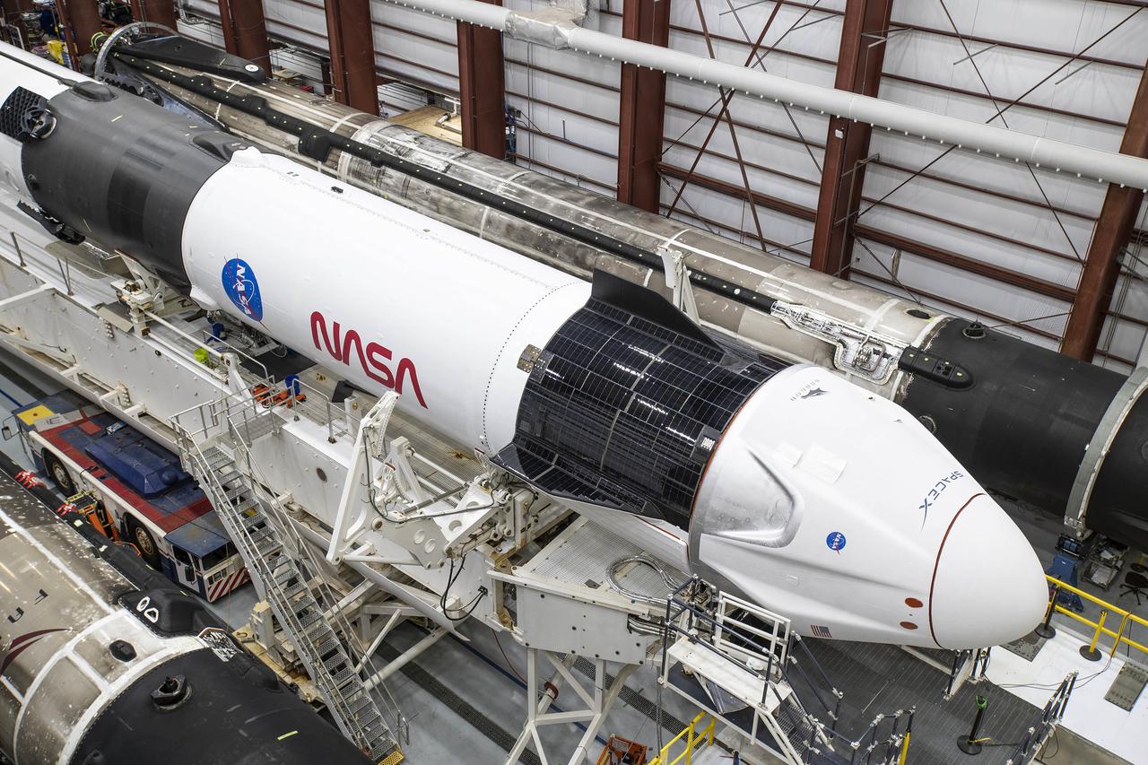 A SpaceX Falcon 9 rocket and Crew Dragon Resilience for NASA SpaceX’s Crew-1 mission are seen inside the SpaceX Hangar at NASA’s Kennedy Space Center in Florida on Nov. 9, 2020, before rollout to Launch Pad 39A. Crew-1 is the first regular crew mission of a U.S. commercial spacecraft with astronauts to the International Space Station as part of NASA’s Commercial Crew Program. The Crew Dragon capsule will launch atop a Falcon 9 rocket from Launch Complex 39A carrying NASA astronauts Michael Hopkins, Victor Glover, Shannon Walker and Japan Aerospace Exploration Agency (JAXA) astronaut Soichi Noguchi to the space station for a six-month science mission.