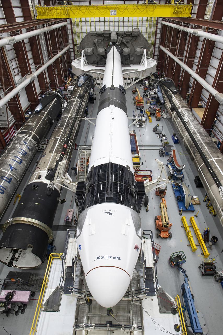 A SpaceX Falcon 9 rocket and Crew Dragon Resilience for NASA SpaceX’s Crew-1 mission are seen inside the SpaceX Hangar at NASA’s Kennedy Space Center in Florida on Nov. 9, 2020, before rollout to Launch Pad 39A. Crew-1 is the first regular crew mission of a U.S. commercial spacecraft with astronauts to the International Space Station as part of NASA’s Commercial Crew Program. The Crew Dragon capsule will launch atop a Falcon 9 rocket from Launch Complex 39A carrying NASA astronauts Michael Hopkins, Victor Glover, Shannon Walker and Japan Aerospace Exploration Agency (JAXA) astronaut Soichi Noguchi to the space station for a six-month science mission.