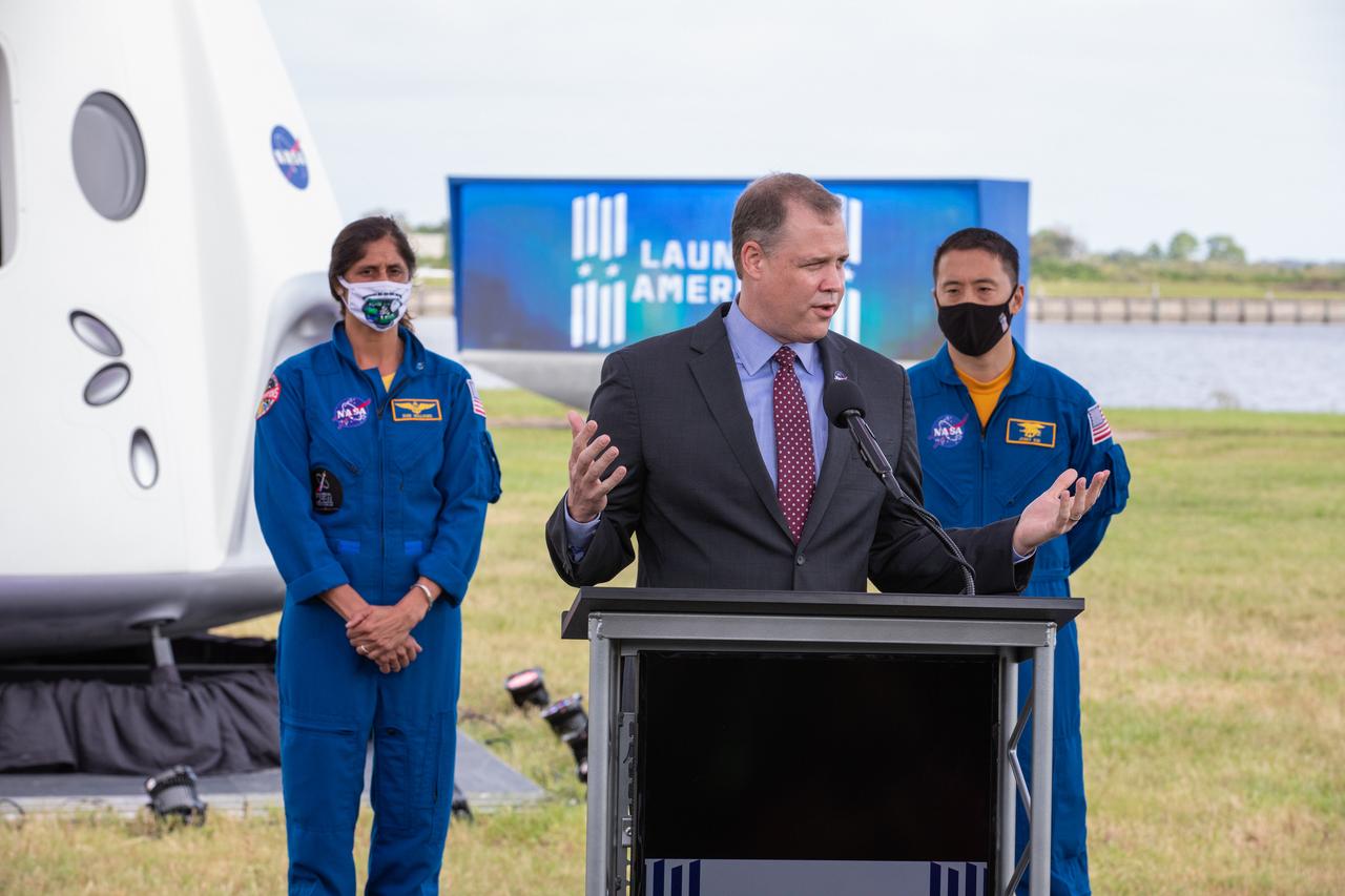 NASA Administrator Jim Bridenstine speaks during a press briefing Nov. 13, 2020, near the Press Site countdown clock at the agency’s Kennedy Space Center in Florida ahead of NASA’s SpaceX Crew-1 launch. Behind him, from left are NASA astronaut Sunita Williams, and NASA astronaut Jonny Kim. Crew-1 is the first regular crew mission of a U.S. commercial spacecraft with astronauts to the International Space Station as part of NASA’s Commercial Crew Program. The SpaceX Crew Dragon Resilience capsule will launch atop the company’s Falcon 9 rocket from Launch Complex 39A to the space station for a six-month science mission.