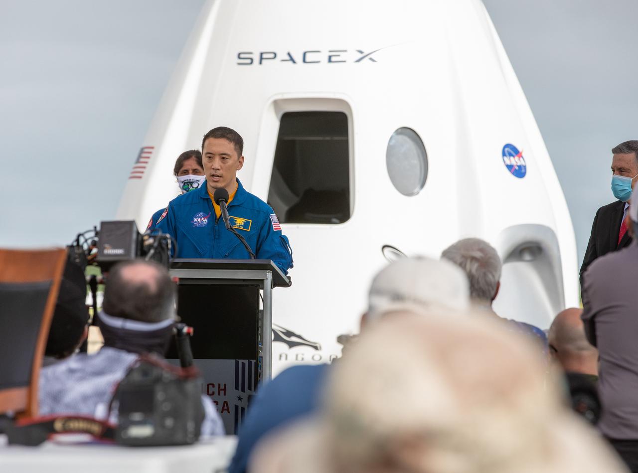 NASA astronaut Jonny Kim, speaks during a press briefing Nov. 13, 2020, near the Press Site countdown clock at the agency’s Kennedy Space Center in Florida ahead of NASA’s SpaceX Crew-1 launch. Behind him is a mock-up of the SpaceX Crew Dragon capsule. Crew-1 is the first regular crew mission of a U.S. commercial spacecraft with astronauts to the International Space Station as part of NASA’s Commercial Crew Program. The SpaceX Crew Dragon Resilience capsule will launch atop the company’s Falcon 9 rocket from Launch Complex 39A to the space station for a six-month science mission.