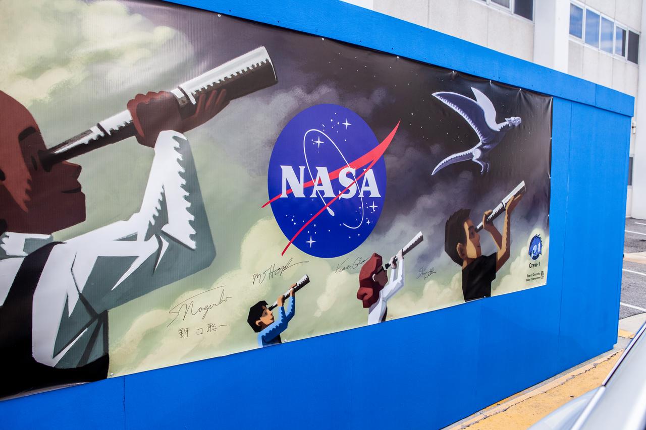 A large mural is on the wall in the hallway leading to the exit where NASA SpaceX’s Crew-1 astronauts will leave the Neil Armstrong Operations and Checkout Building at NASA’s Kennedy Space Center in Florida on Nov. 15, 2020. NASA astronauts Michael Hopkins, Victor Glover and Shannon Walker, and JAXA astronaut Soichi Noguchi, will board two Tesla vehicles for the trip to Launch Complex 39A. Crew-1 is the first regular crew mission of a U.S. commercial spacecraft with astronauts to the International Space Station as part of NASA’s Commercial Crew Program. The SpaceX Crew Dragon Resilience capsule will launch atop the company’s Falcon 9 rocket from Pad 39A to the space station for a six-month science mission.