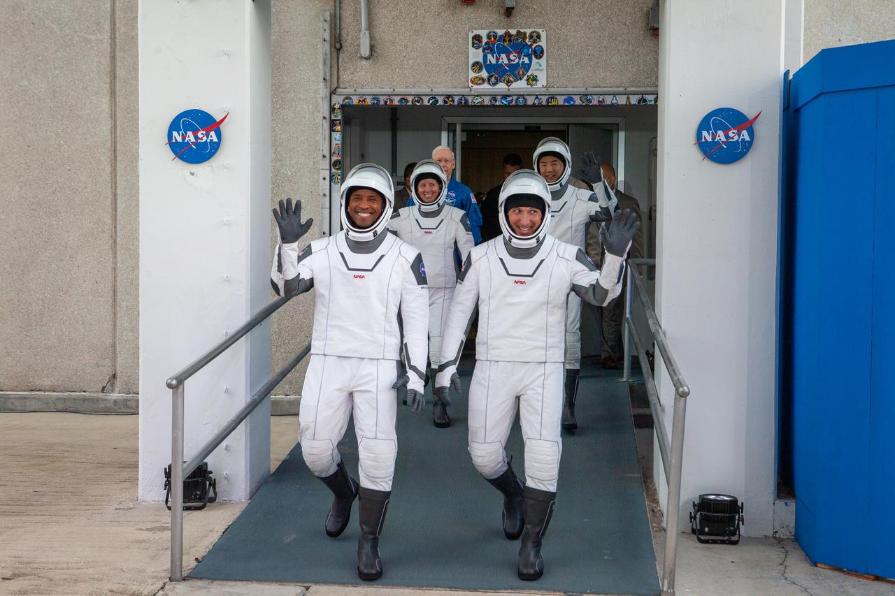 NASA SpaceX’s Crew-1 astronauts emerge from the Neil Armstrong Operations and Checkout Building at NASA’s Kennedy Space Center in Florida on Nov. 15, 2020. In front, from left are NASA astronaut Victor Glover, pilot, and NASA astronaut Michael Hopkins, spacecraft commander. Behind them, from left are NASA astronaut Shannon Walker, mission specialist, and JAXA astronaut Soichi Noguchi, mission specialist. They will board two Tesla vehicles for the trip to Launch Complex 39A. Crew-1 is the first regular crew mission of a U.S. commercial spacecraft with astronauts to the International Space Station as part of NASA’s Commercial Crew Program. The SpaceX Crew Dragon Resilience capsule will launch atop the company’s Falcon 9 rocket from Pad 39A to the space station for a six-month science mission.