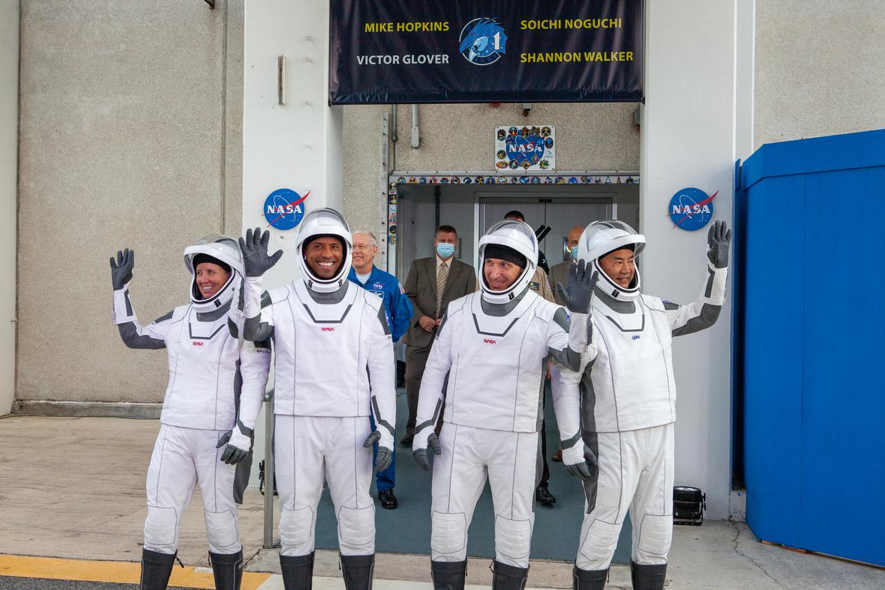 NASA SpaceX’s Crew-1 astronauts emerge from the Neil Armstrong Operations and Checkout Building at NASA’s Kennedy Space Center in Florida on Nov. 15, 2020 and stop to wave to family members, guests and members of the media. From left are NASA astronaut Shannon Walker, mission specialist; Victor Glover, pilot; NASA astronaut Michael Hopkins, spacecraft commander and JAXA astronaut Soichi Noguchi, mission specialist. They will board two Tesla vehicles for the trip to Launch Complex 39A. Crew-1 is the first regular crew mission of a U.S. commercial spacecraft with astronauts to the International Space Station as part of NASA’s Commercial Crew Program. The SpaceX Crew Dragon Resilience capsule will launch atop the company’s Falcon 9 rocket from Pad 39A to the space station for a six-month science mission.