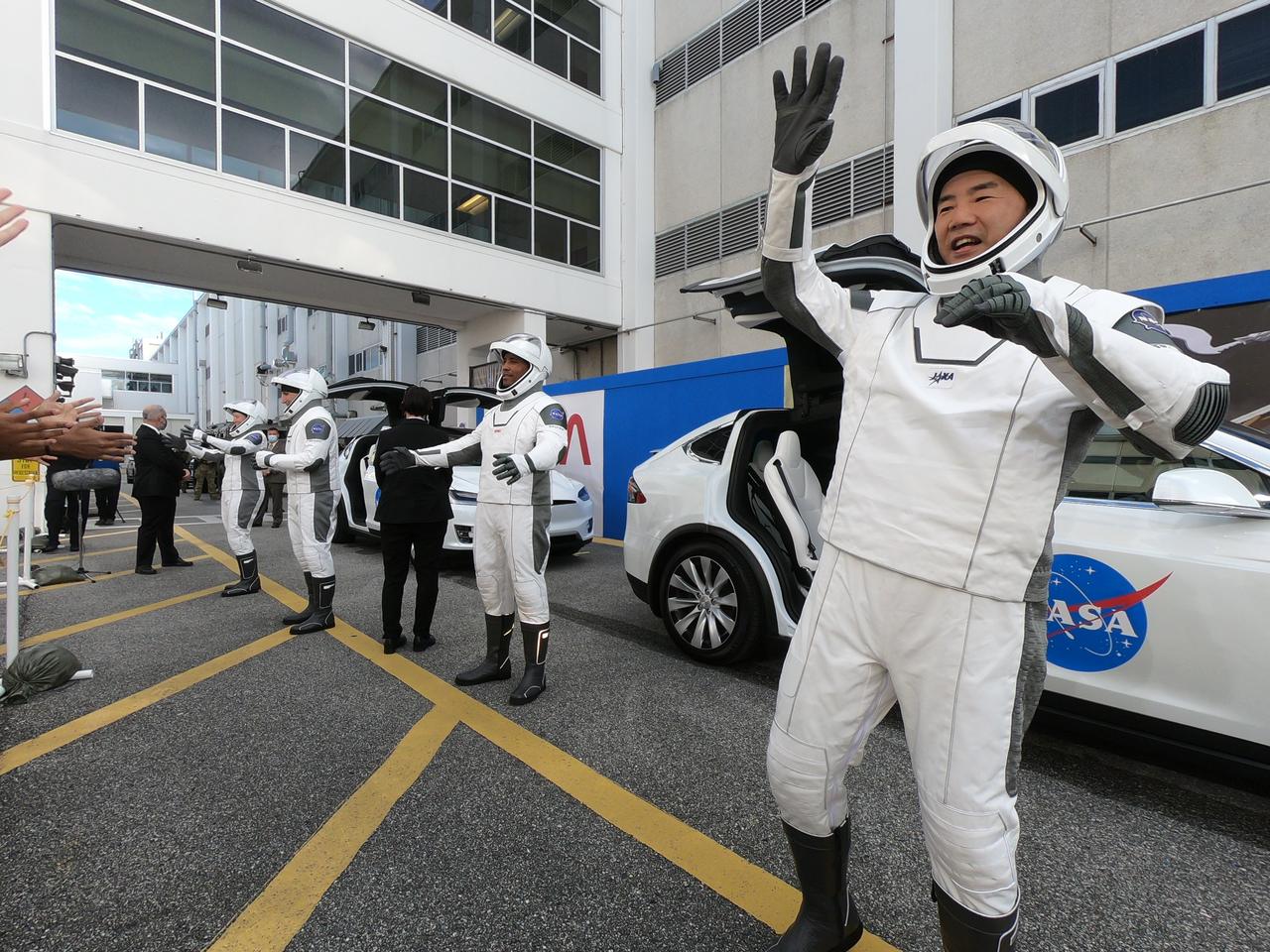 NASA SpaceX’s Crew-1 astronauts get ready to board two Tesla vehicles for the trip to Launch Complex 39A after emerging from the Neil Armstrong Operations and Checkout Building at NASA’s Kennedy Space Center in Florida on Nov. 15, 2020. In view at far right is JAXA astronaut Soichi Noguchi, mission specialist. From left are NASA astronauts Shannon Walker, mission specialist; Michael Hopkins, spacecraft commander; and Victor Glover, pilot. Crew-1 is the first regular crew mission of a U.S. commercial spacecraft with astronauts to the International Space Station as part of NASA’s Commercial Crew Program. The SpaceX Crew Dragon Resilience capsule will launch atop the company’s Falcon 9 rocket from Pad 39A to the space station for a six-month science mission.
