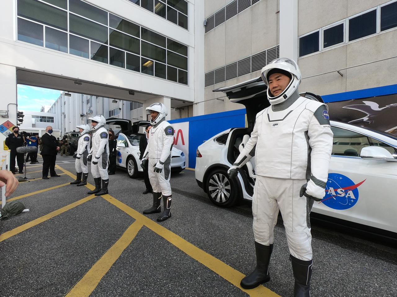 NASA SpaceX’s Crew-1 astronauts get ready to board two Tesla vehicles for the trip to Launch Complex 39A after emerging from the Neil Armstrong Operations and Checkout Building at NASA’s Kennedy Space Center in Florida on Nov. 15, 2020. In view at far right is JAXA astronaut Soichi Noguchi, mission specialist. From left are NASA astronauts Shannon Walker, mission specialist; Michael Hopkins, spacecraft commander; and Victor Glover, pilot. Crew-1 is the first regular crew mission of a U.S. commercial spacecraft with astronauts to the International Space Station as part of NASA’s Commercial Crew Program. The SpaceX Crew Dragon Resilience capsule will launch atop the company’s Falcon 9 rocket from Pad 39A to the space station for a six-month science mission.
