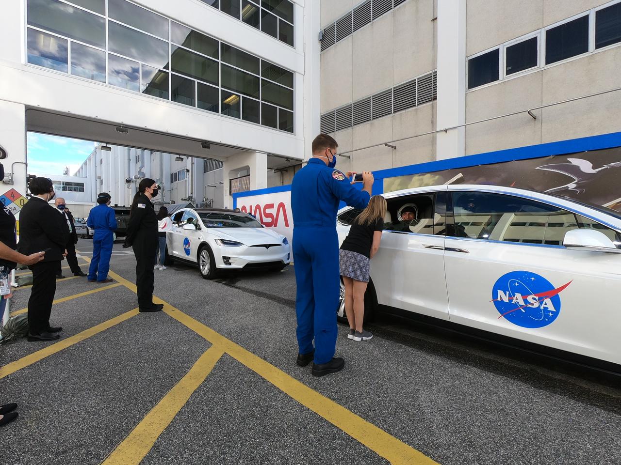 Family members of NASA SpaceX’s Crew-1 astronauts say goodbye as the astronauts are secured inside two Tesla vehicles for the trip to Launch Complex 39A after emerging from the Neil Armstrong Operations and Checkout Building at NASA’s Kennedy Space Center in Florida on Nov. 15, 2020. NASA astronauts Shannon Walker, mission specialist; Michael Hopkins, spacecraft commander; and Victor Glover, pilot; along with JAXA astronaut Soichi Noguchi, mission specialist, will board the Crew Dragon at the launch pad. Crew-1 is the first regular crew mission of a U.S. commercial spacecraft with astronauts to the International Space Station as part of NASA’s Commercial Crew Program. The SpaceX Crew Dragon Resilience capsule will launch atop the company’s Falcon 9 rocket from Pad 39A to the space station for a six-month science mission.