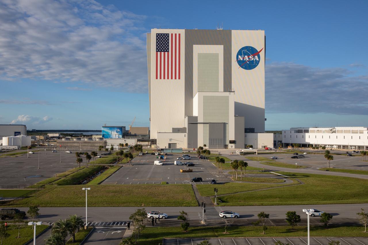 A view of the iconic Vehicle Assembly Building from the observation deck of the Operations Support Building II at NASA’s Kennedy Space Center in Florida on Nov. 15, 2020. A SpaceX Falcon 9 rocket with the Crew Dragon Resilience atop is on Launch Pad 39A for the Crew-1 mission to the International Space Station. Crew-1 is the first regular crew mission of a U.S. commercial spacecraft with astronauts to the space station as part of NASA’s Commercial Crew Program. The Crew Dragon will carry NASA astronauts Michael Hopkins, Victor Glover, Shannon Walker and Japan Aerospace Exploration Agency (JAXA) astronaut Soichi Noguchi to the space station for a six-month science mission.