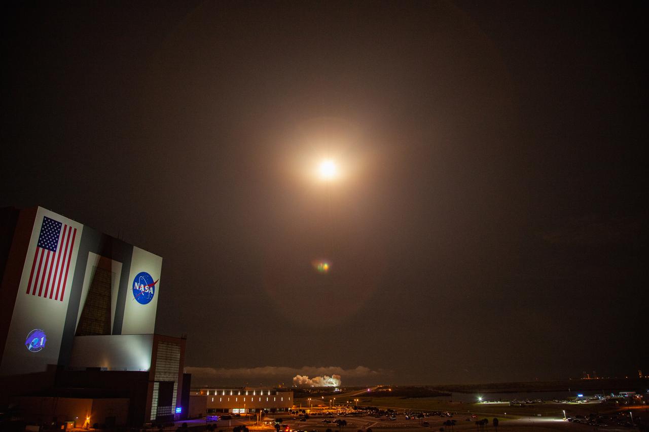 With a view of the iconic Vehicle Assembly Building at left, a SpaceX Falcon 9 rocket soars upward from Launch Complex 39A at NASA’s Kennedy Space Center in Florida on Nov. 15, 2020, carrying the company’s Crew Dragon Resilience capsule. Launch time was at 7:27 p.m. EST. Onboard the capsule are NASA’s SpaceX Crew-1 astronauts, Michael Hopkins, spacecraft commander; Victor Glover, pilot; Shannon Walker, mission specialist; and Japan Aerospace Exploration Agency astronaut Soichi Noguchi, mission specialist. Crew-1 is the first regular crew mission of a U.S. commercial spacecraft with astronauts to the International Space Station as part of NASA’s Commercial Crew Program. The Crew Dragon will dock with the space station and the crew will remain on the orbiting laboratory for a six-month science mission.
