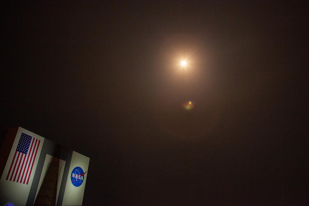 With a view of the iconic Vehicle Assembly Building at left, a SpaceX Falcon 9 rocket soars upward from Launch Complex 39A at NASA’s Kennedy Space Center in Florida on Nov. 15, 2020, carrying the company’s Crew Dragon Resilience capsule. Launch time was at 7:27 p.m. EST. Onboard the capsule are NASA’s SpaceX Crew-1 astronauts, Michael Hopkins, spacecraft commander; Victor Glover, pilot; Shannon Walker, mission specialist; and Japan Aerospace Exploration Agency astronaut Soichi Noguchi, mission specialist. Crew-1 is the first regular crew mission of a U.S. commercial spacecraft with astronauts to the International Space Station as part of NASA’s Commercial Crew Program. The Crew Dragon will dock with the space station and the crew will remain on the orbiting laboratory for a six-month science mission.