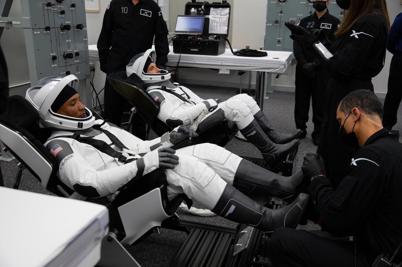 Inside the crew suit-up room in the Neil Armstrong Operations and Checkout Building at NASA’s Kennedy Space Center in Florida, on Nov. 15, 2020, the suit-up team helps Crew-1 astronauts into the SpaceX spacesuits. From left, NASA astronaut Victor Glover, pilot, and NASA astronaut Michael Hopkins, spacecraft commander, are wearing SpaceX spacesuits in preparation for NASA SpaceX’s Crew-1 mission. Crew-1 is the first regular crew mission of a U.S. commercial spacecraft with astronauts to the International Space Station as part of NASA’s Commercial Crew Program. The SpaceX Crew Dragon Resilience capsule will launch atop the company’s Falcon 9 rocket from Launch Complex 39A to the space station for a six-month science mission.