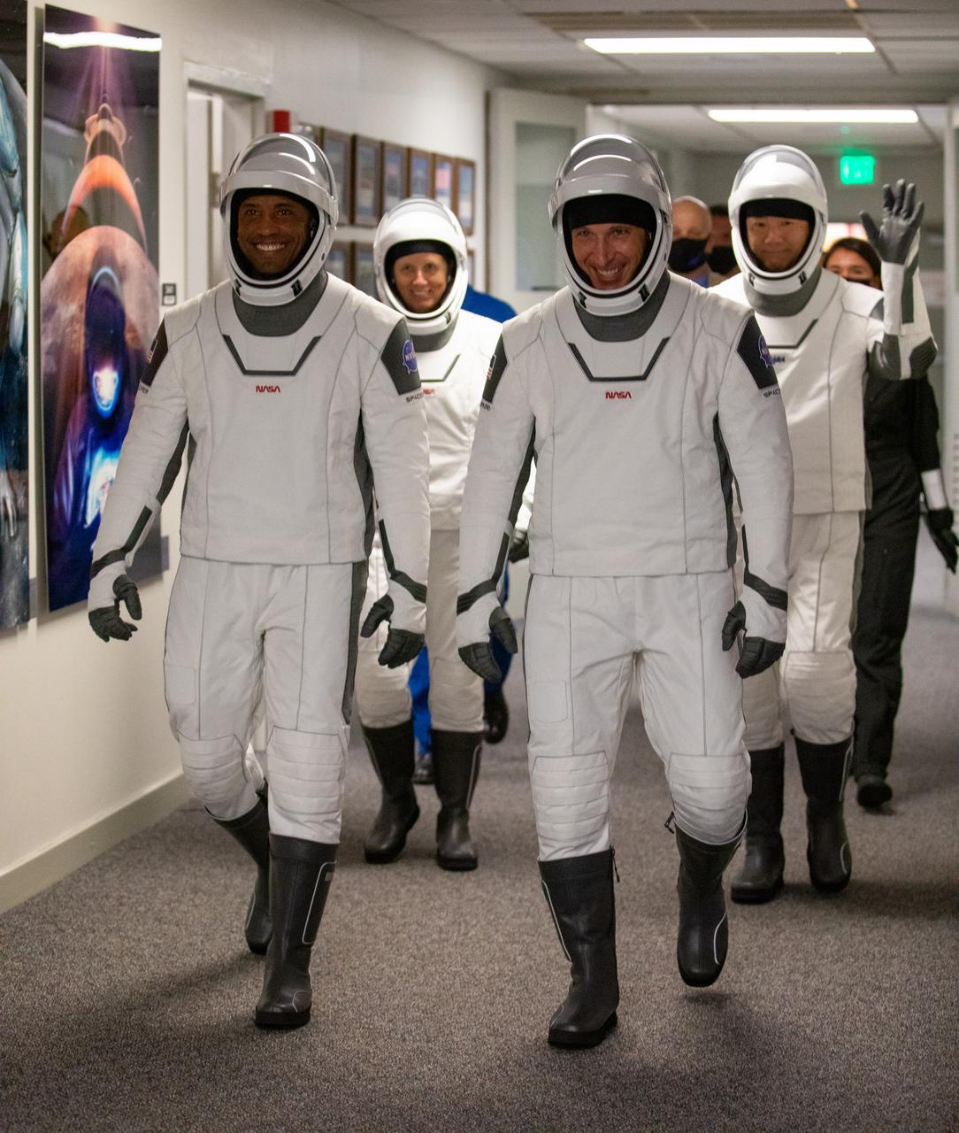The NASA SpaceX Crew-1 astronauts emerge from the Neil Armstrong Operations and Checkout Building at NASA’s Kennedy Space Center in Florida on Nov. 15, 2020. In front, from left are NASA astronaut Victor Glover, pilot; and NASA astronaut Michael Hopkins, spacecraft commander. Behind them, from left are NASA astronaut Shannon Walker, mission specialist, and JAXA astronaut Soichi Noguchi, mission specialist. They will board two Tesla vehicles for the trip to Launch Complex 39A. Crew-1 is the first regular crew mission of a U.S. commercial spacecraft with astronauts to the International Space Station as part of NASA’s Commercial Crew Program. The SpaceX Crew Dragon Resilience capsule will launch atop the company’s Falcon 9 rocket from Pad 39A to the space station for a six-month science mission.