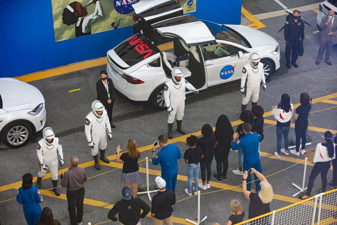 The NASA SpaceX Crew-1 astronauts visit with family members after emerging from the Neil Armstrong Operations and Checkout Building at NASA’s Kennedy Space Center in Florida on Nov. 15, 2020. From left, are NASA astronaut Shannon Walker, mission specialist; NASA astronaut Michael Hopkins, spacecraft commander; NASA astronaut Victor Glover, pilot; and JAXA astronaut Soichi Noguchi, mission specialist. They will board two Tesla vehicles for the trip to Launch Complex 39A. Crew-1 is the first regular crew mission of a U.S. commercial spacecraft with astronauts to the International Space Station as part of NASA’s Commercial Crew Program. The SpaceX Crew Dragon Resilience capsule will launch atop the company’s Falcon 9 rocket from Pad 39A to the space station for a six-month science mission.