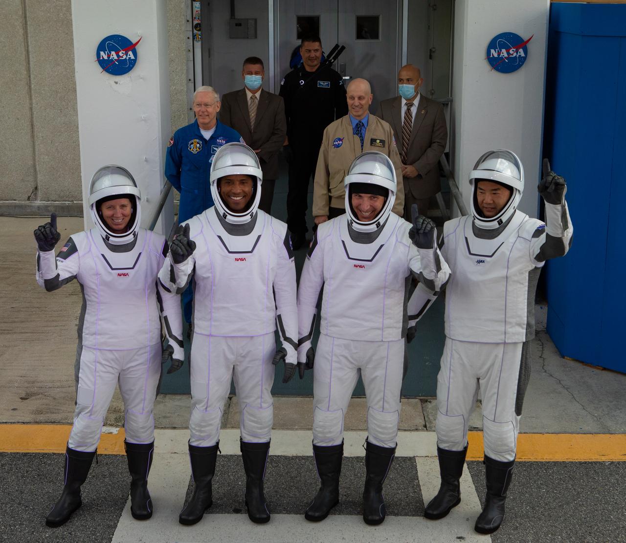The NASA SpaceX Crew-1 astronauts emerge from the Neil Armstrong Operations and Checkout Building at NASA’s Kennedy Space Center in Florida on Nov. 15, 2020. From left are NASA astronaut Shannon Walker, mission specialist; NASA astronaut Victor Glover, pilot; NASA astronaut Michael Hopkins, spacecraft commander; and JAXA astronaut Soichi Noguchi, mission specialist. They will board two Tesla vehicles for the trip to Launch Complex 39A. Crew-1 is the first regular crew mission of a U.S. commercial spacecraft with astronauts to the International Space Station as part of NASA’s Commercial Crew Program. The SpaceX Crew Dragon Resilience capsule will launch atop the company’s Falcon 9 rocket from Pad 39A to the space station for a six-month science mission.