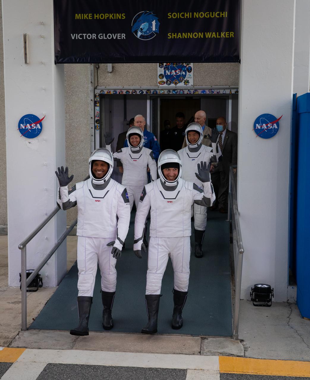 The NASA SpaceX Crew-1 astronauts emerge from the Neil Armstrong Operations and Checkout Building at NASA’s Kennedy Space Center in Florida on Nov. 15, 2020. In front, from left are NASA astronaut Victor Glover, pilot, and NASA astronaut Michael Hopkins, spacecraft commander. Behind them, from left are NASA astronaut Shannon Walker, and JAXA astronaut Soichi Noguchi, mission specialist. They will board two Tesla vehicles for the trip to Launch Complex 39A. Crew-1 is the first regular crew mission of a U.S. commercial spacecraft with astronauts to the International Space Station as part of NASA’s Commercial Crew Program. The SpaceX Crew Dragon Resilience capsule will launch atop the company’s Falcon 9 rocket from Pad 39A to the space station for a six-month science mission.