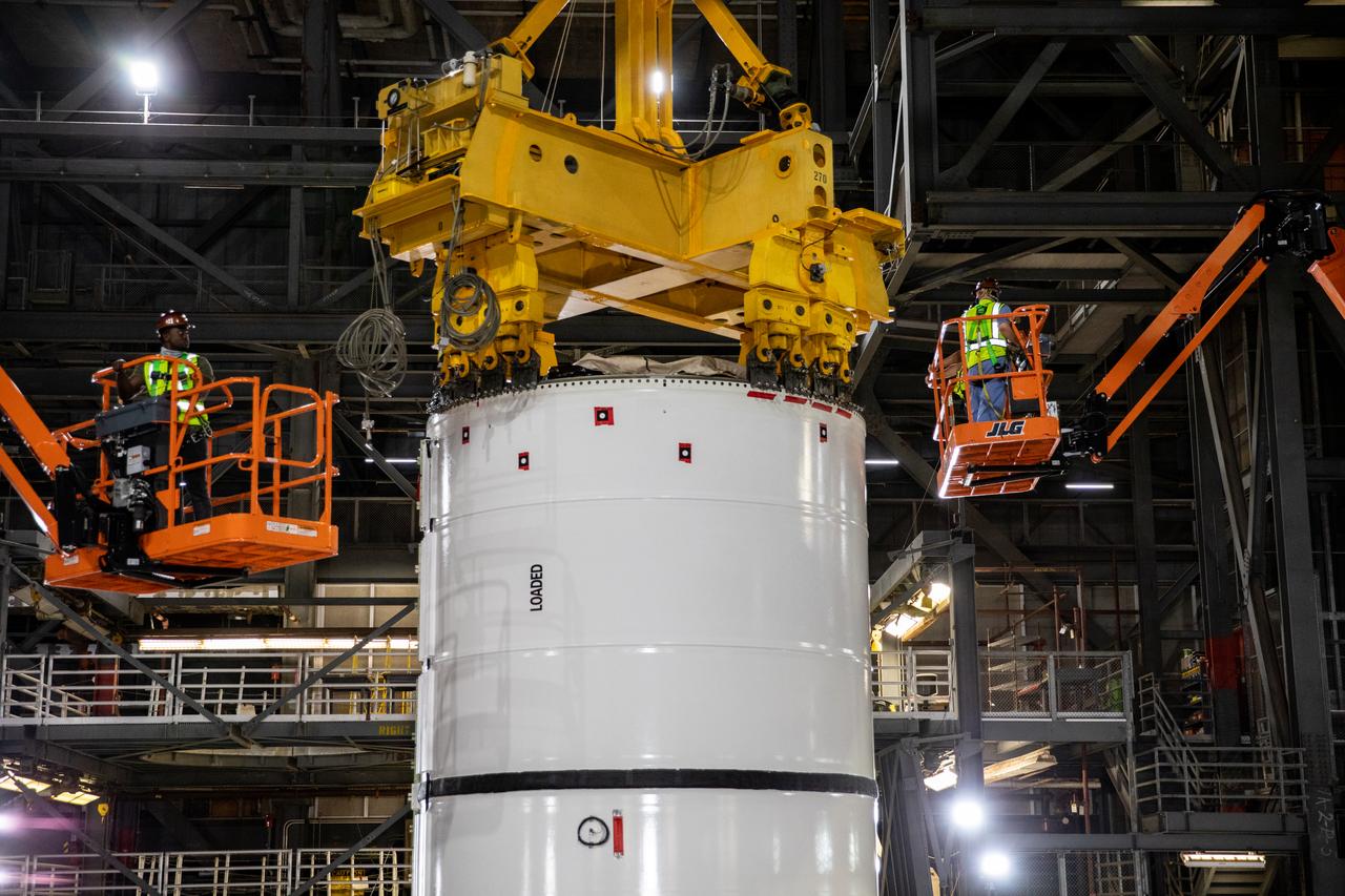In High Bay 4 of the Vehicle Assembly Building (VAB) at NASA’s Kennedy Space Center in Florida, one of the Artemis I aft booster segments for the Space Launch System is being prepared for its lift up and lowering onto the mobile launcher in High Bay 3 for stacking operations on Nov. 20, 2020. Workers with Exploration Ground Systems and contractor Jacobs teams will stack the twin five-segment boosters on the mobile launcher in High Bay 3 over a number of weeks. When the core stage arrives, it will join the boosters on the mobile launcher, followed by the interim cryogenic propulsion stage and Orion spacecraft. Manufactured by Northrop Grumman in Utah, the twin boosters provide more than 75 percent of the total SLS thrust at launch. The SLS is managed by Marshall Space Flight Center in Huntsville, Alabama. Under the Artemis program, NASA will land the first woman and the next man on the Moon by 2024. The first in a series of increasingly complex missions, Artemis I will test the Orion spacecraft and SLS as an integrated system ahead of crewed flights to the Moon.