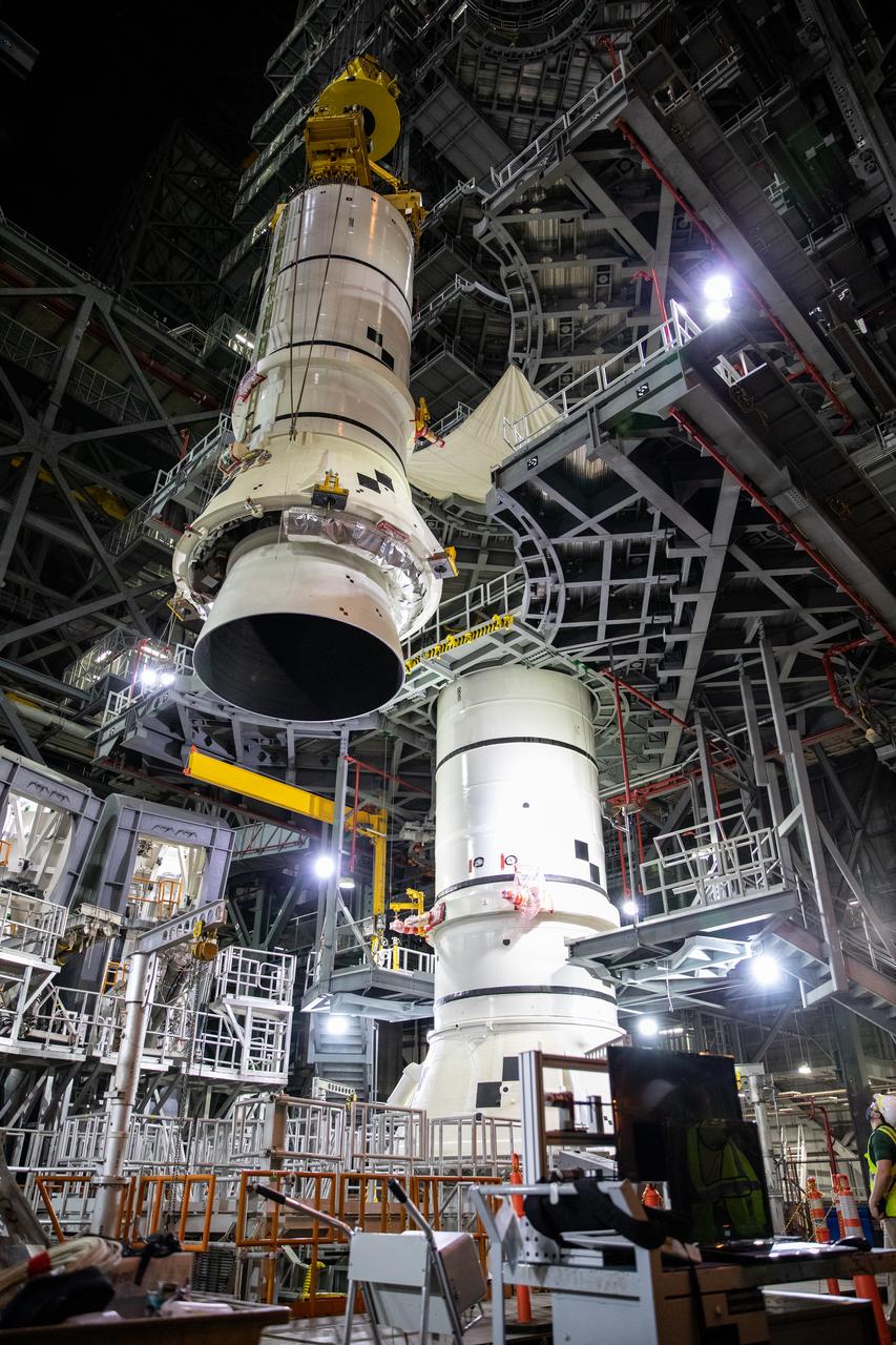In the Vehicle Assembly Building (VAB) at NASA’s Kennedy Space Center in Florida, the second of two Artemis I aft booster segments for the Space Launch System is lowered by crane onto the mobile launcher in High Bay 3 on Nov. 24, 2020. Workers with Exploration Ground Systems and contractor Jacobs teams will stack the twin five-segment boosters on the mobile launcher over a number of weeks. When the core stage arrives, it will join the boosters on the mobile launcher, followed by the interim cryogenic propulsion stage and Orion spacecraft. Manufactured by Northrop Grumman in Utah, the twin boosters provide more than 75 percent of the total SLS thrust at launch. The SLS is managed by Marshall Space Flight Center in Huntsville, Alabama. Under the Artemis program, NASA will land the first woman and the next man on the Moon by 2024. The first in a series of increasingly complex missions, Artemis I will test the Orion spacecraft and SLS as an integrated system ahead of crewed flights to the Moon.
