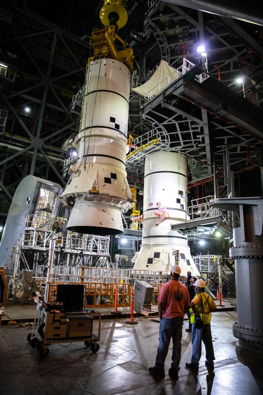 In the Vehicle Assembly Building (VAB) at NASA’s Kennedy Space Center in Florida, the second of two Artemis I aft booster segments for the Space Launch System is lowered by crane onto the mobile launcher in High Bay 3 on Nov. 24, 2020. Workers with Exploration Ground Systems and contractor Jacobs teams will stack the twin five-segment boosters on the mobile launcher over a number of weeks. When the core stage arrives, it will join the boosters on the mobile launcher, followed by the interim cryogenic propulsion stage and Orion spacecraft. Manufactured by Northrop Grumman in Utah, the twin boosters provide more than 75 percent of the total SLS thrust at launch. The SLS is managed by Marshall Space Flight Center in Huntsville, Alabama. Under the Artemis program, NASA will land the first woman and the next man on the Moon by 2024. The first in a series of increasingly complex missions, Artemis I will test the Orion spacecraft and SLS as an integrated system ahead of crewed flights to the Moon.