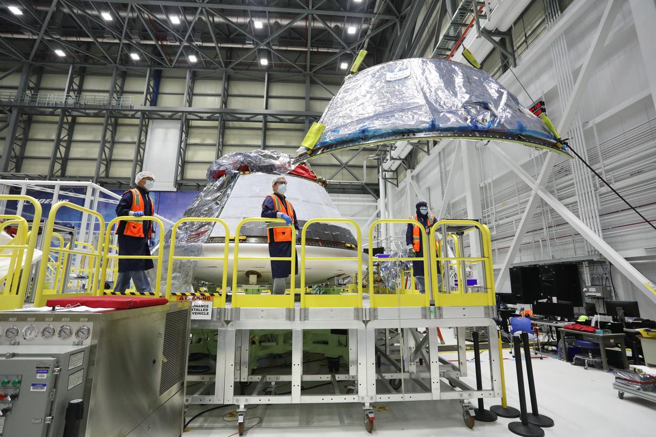 Boeing technicians install back shells on the Orbital Flight Test-2 (OFT-2) Starliner crew module inside the company’s Commercial Crew and Cargo Processing Facility at NASA’s Kennedy Space Center in Florida on December 2, 2020. During the OFT-2 mission, the uncrewed Starliner spacecraft will fly to the International Space Station for NASA’s Commercial Crew Program.