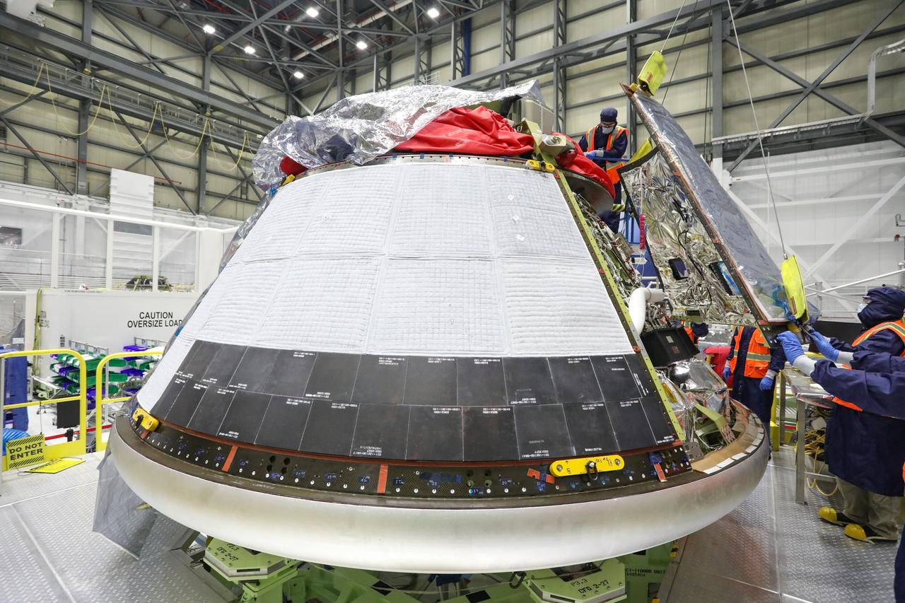Boeing technicians install back shells on the Orbital Flight Test-2 (OFT-2) Starliner crew module inside the company’s Commercial Crew and Cargo Processing Facility at NASA’s Kennedy Space Center in Florida on December 2, 2020. During the OFT-2 mission, the uncrewed Starliner spacecraft will fly to the International Space Station for NASA’s Commercial Crew Program.