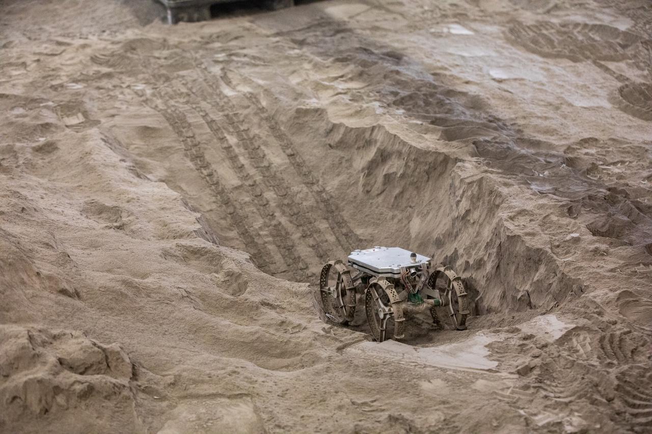 The Astrobotic CubeRover traverses a trench in the Granular Mechanics and Regolith Operations Laboratory regolith bin at NASA’s Kennedy Space Center in Florida on Dec. 10, 2020. The regolith bin simulates the mechanical properties of the Moon’s surface. NASA and Astrobotic employees put the CubeRover through a series of more than 150 mobility tests over several days to evaluate and improve wheel design.