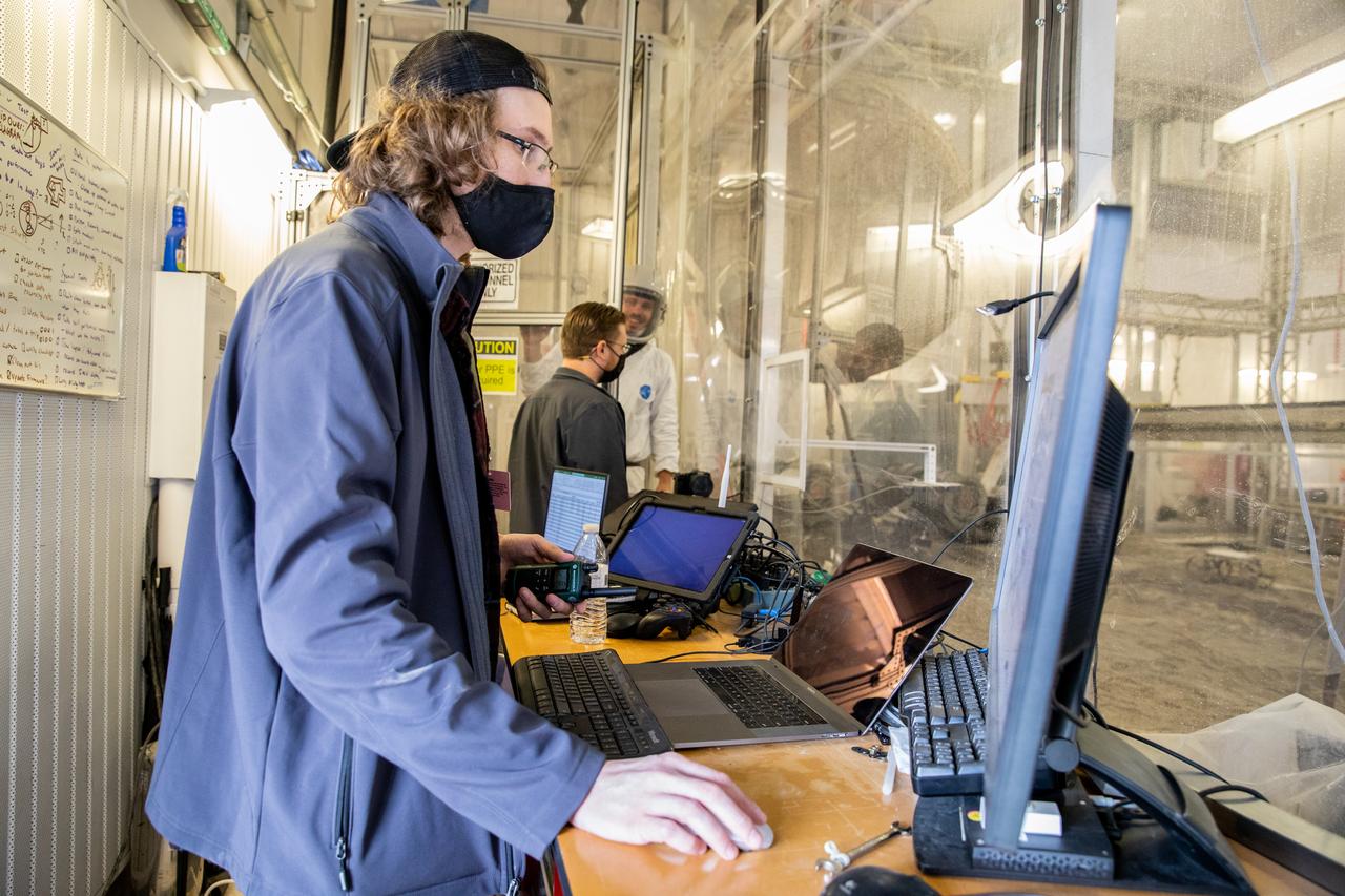Taylor Whitaker, flight software engineer, monitors the progress of the Astrobotic CubeRover during its test run in the Granular Mechanics and Regolith Operations Lab regolith bin at NASA’s Kennedy Space Center in Florida on Dec. 10, 2020. The regolith bin simulates the mechanical properties of the Moon’s surface. NASA and Astrobotic employees put the CubeRover through a series of more than 150 mobility tests over several days to evaluate and improve wheel design.