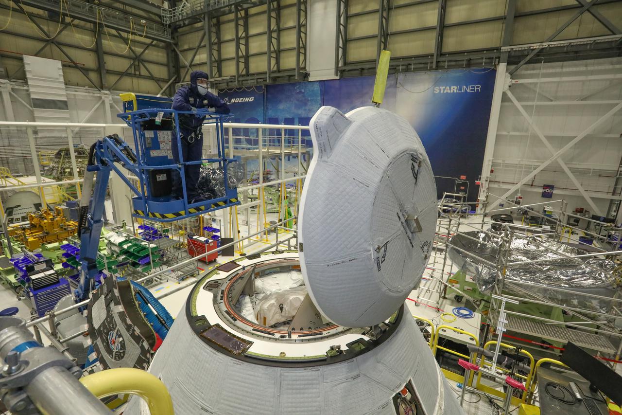 A technician observes the functional test of the NASA Docking System (NDS) cover in the Commercial Crew and Cargo Processing Facility at Kennedy Space Center in Florida on Jan. 2, 2021. The test was conducted in preparation for Boeing’s second Orbital Flight Test (OFT-2), as part of NASA’s Commercial Crew Program. The cover is designed to protect the components that connect the spacecraft to the International Space Station. 