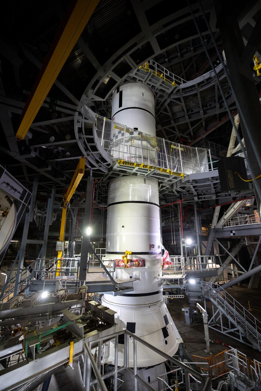 In High Bay 3 of the Vehicle Assembly Building at NASA’s Kennedy Space Center in Florida, the left-hand center booster segment for Artemis I is lowered onto the aft booster segment on the mobile launcher for the Space Launch System (SLS) on Jan. 7, 2021. Workers with Exploration Ground Systems and contractor Jacobs teams will stack the twin five-segment boosters on the mobile launcher in High Bay 3 over a number of weeks. When the core stage arrives, it will join the boosters on the mobile launcher, followed by the interim cryogenic propulsion stage and Orion spacecraft. Manufactured by Northrop Grumman in Utah, the twin boosters provide more than 75 percent of the total SLS thrust at launch. The SLS is managed by Marshall Space Flight Center in Huntsville, Alabama. Under the Artemis program, NASA will land the first woman and the next man on the Moon by 2024. The first in a series of increasingly complex missions, Artemis I will test the Orion spacecraft and SLS as an integrated system ahead of crewed flights to the Moon.