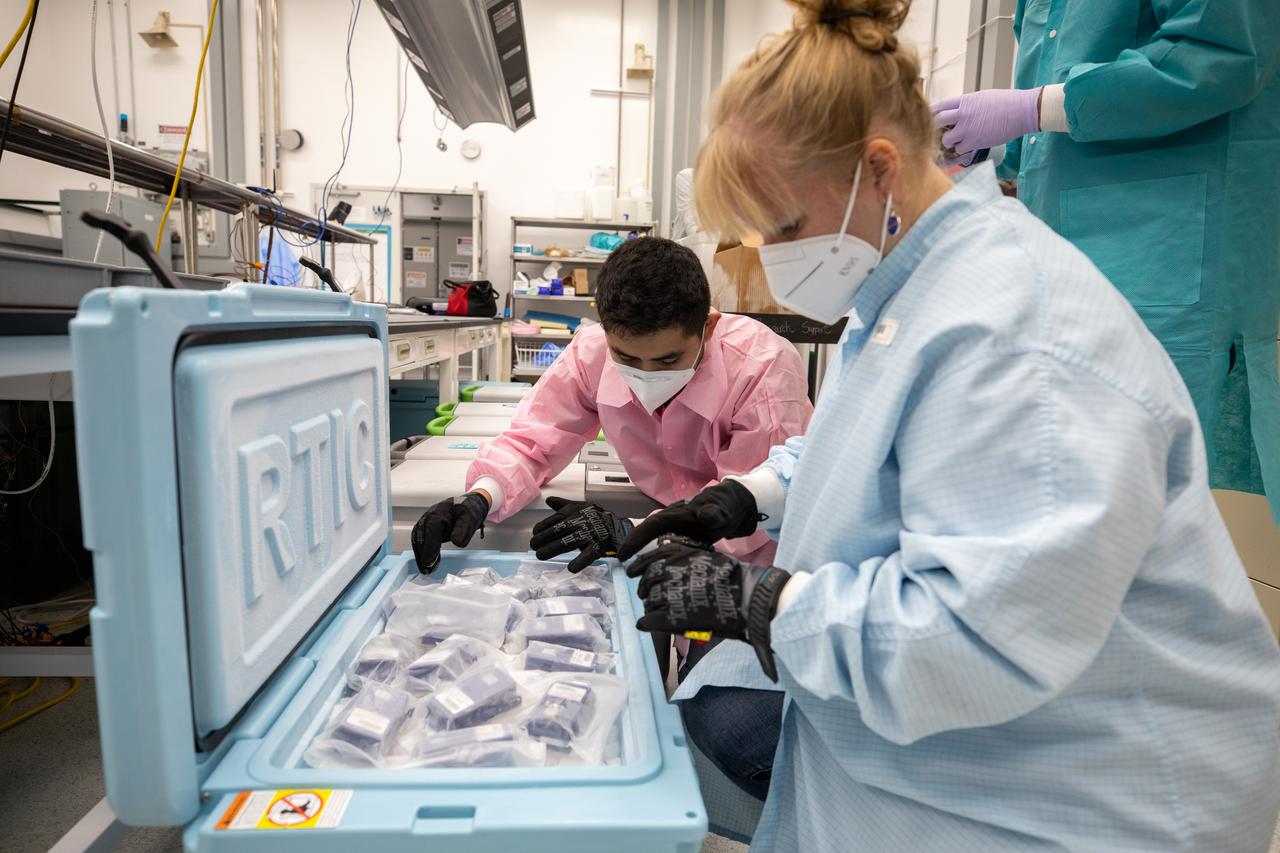 Members of the cold stowage team unpack science experiments inside the Space Station Processing Facility at NASA’s Kennedy Space Center in Florida on Jan. 14, 2021. The experiments returned to Earth on SpaceX’s 21st commercial resupply services mission (CRS-21). Making its successful parachute-assisted splashdown west of Tampa off the Florida coast, at 8:26 p.m. EST on Jan. 13, the SpaceX cargo Dragon returned more than 4,400 pounds of scientific experiments and other cargo from the International Space Station. After splashdown, SpaceX loaded Dragon aboard their Go Navigator recovery ship and packed an Airbus H225 helicopter with the time-sensitive research cargo for delivery to Kennedy. The upgraded cargo Dragon capsule also boasts double the powered locker capacity to preserve science samples, allowing for a significant increase in the research that can be carried back to Earth.