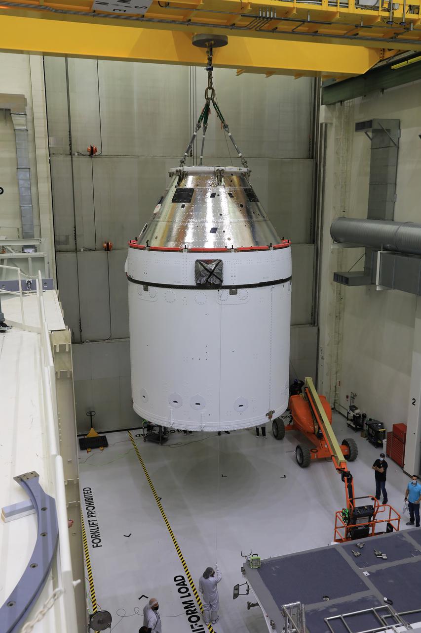 Orion is revealed for one of the final times on Jan. 14, as it is lowered by crane onto its transport pallet inside the Neil Armstrong Operations and Checkout Building at NASA’s Kennedy Space Center in Florida, along its path to the pad ahead of the Artemis I launch. Teams across the globe have worked tirelessly to assemble the spacecraft which will receive a protective covering prior to departing for the Multi-Payload Processing Facility to begin ground processing by the Exploration Ground Systems and Jacobs teams.
