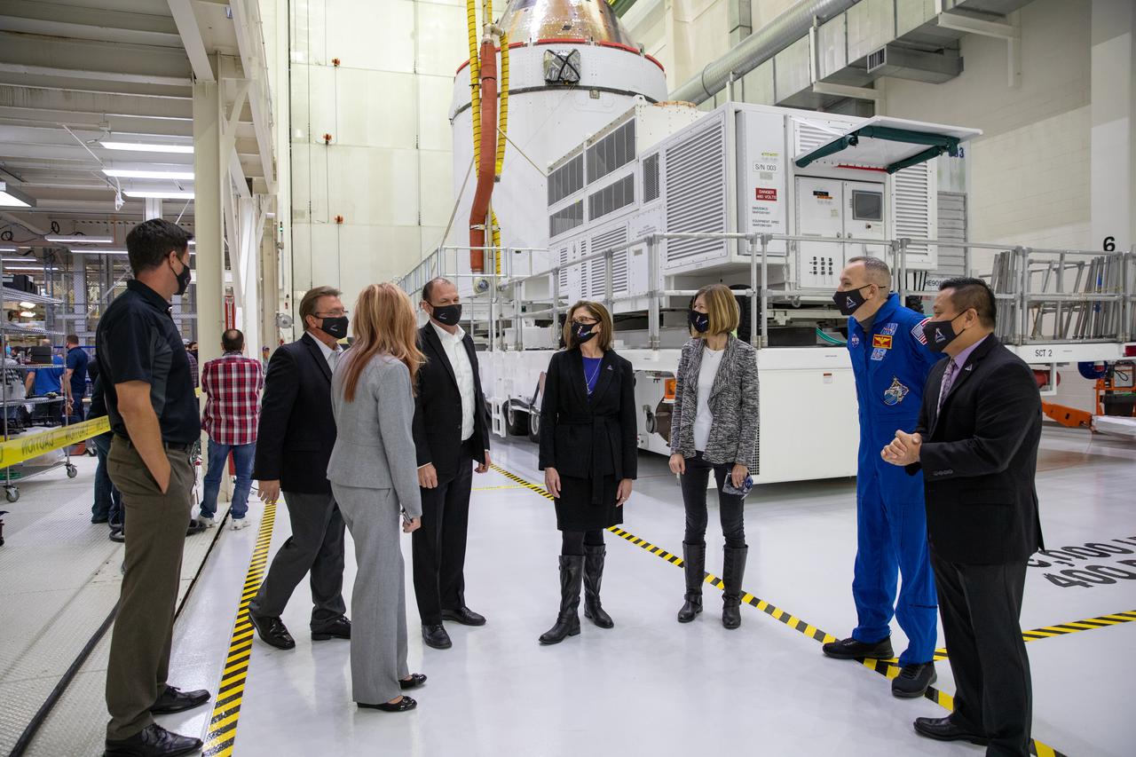 Orion is revealed for one of the final times on Jan. 14, as it is readied atop its transport pallet from the Neil Armstrong Operations and Checkout Building at NASA’s Kennedy Space Center in Florida, along its path to the pad ahead of the Artemis I launch. Inside the high bay, from left, are Nathan Varn, Lockheed Martin Production Control director; Jules Schneider, Lockheed Martin director of Orion Assembly, Test and Launch Operations at Kennedy; Kelly DeFazio, Lockheed Martin Orion Program director for production operations; Tony Antonelli, Lockheed Martin Orion Program director and Artemis II Mission director; Cathy Koerner, Orion Program manager; Kathy Lueders, associate administrator of the Human Exploration and Operations Mission Directorate; astronaut Randy Bresnik; and Howard Hu, Orion deputy program manager. Teams across the globe have worked tirelessly to assemble the spacecraft, which will receive a protective covering prior to departing for the Multi-Payload Processing Facility to begin ground processing by the Exploration Ground Systems and Jacobs teams.