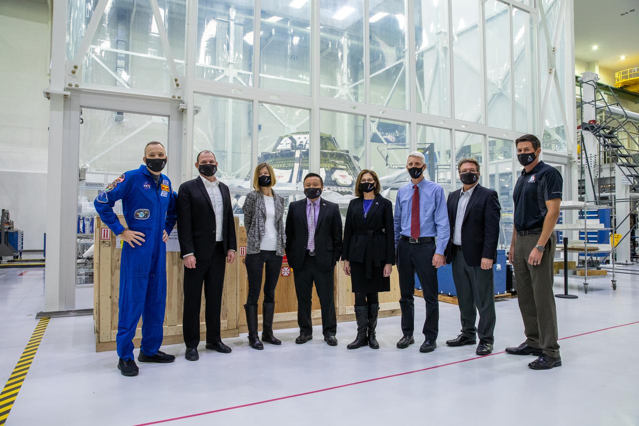 Kathy Lueders, third from left, associate administrator of the Human Exploration and Operations Mission Directorate, tours the Neil Armstrong Operations and Checkout Building high bay at NASA’s Kennedy Space Center in Florida on Jan. 14, 2021. In the background is the Orion crew module for the Artemis II mission. From left are NASA astronaut Randy Bresnik; Tony Antonelli, Lockheed Martin Orion Program director and Artemis II Mission director; Howard Hu, Orion deputy program manager; Cathy Koerner, Orion Program manager; Scott Wilson, Orion Production Operations manager; Jules Schneider, Lockheed Martin director of Orion Assembly, Test and Launch Operations at Kennedy; and Nathan Varn, Lockheed Martin Production Control director. The group also viewed the Orion spacecraft for Artemis I as it was lowered onto a transporter for the move to the Multi-Payload Processing Facility to begin ground processing by the Exploration Ground Systems and Jacobs teams.