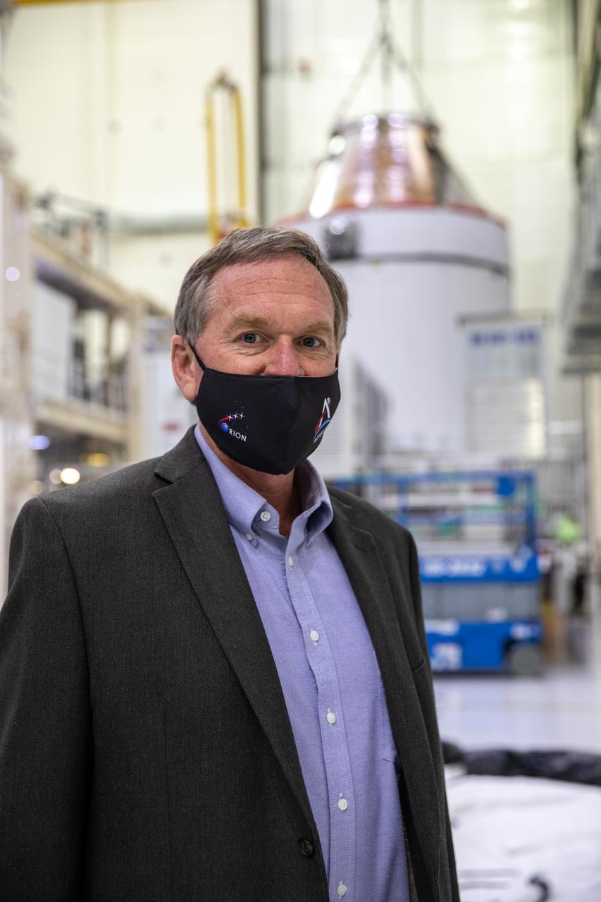 Orion is revealed for one of the final times on Jan. 14, as it is readied atop its transport pallet from the Neil Armstrong Operations and Checkout Building at NASA’s Kennedy Space Center in Florida, along its path to the pad ahead of the Artemis I launch. Orion was officially transferred from the Orion Program to Exploration Ground Systems (EGS). Mike Bolger, EGS manager, stands inside the high bay with Orion in the background. Teams across the globe have worked tirelessly to assemble the spacecraft which, will receive a protective covering prior to departing for the Multi-Payload Processing Facility to begin ground processing by the EGS and Jacobs teams.