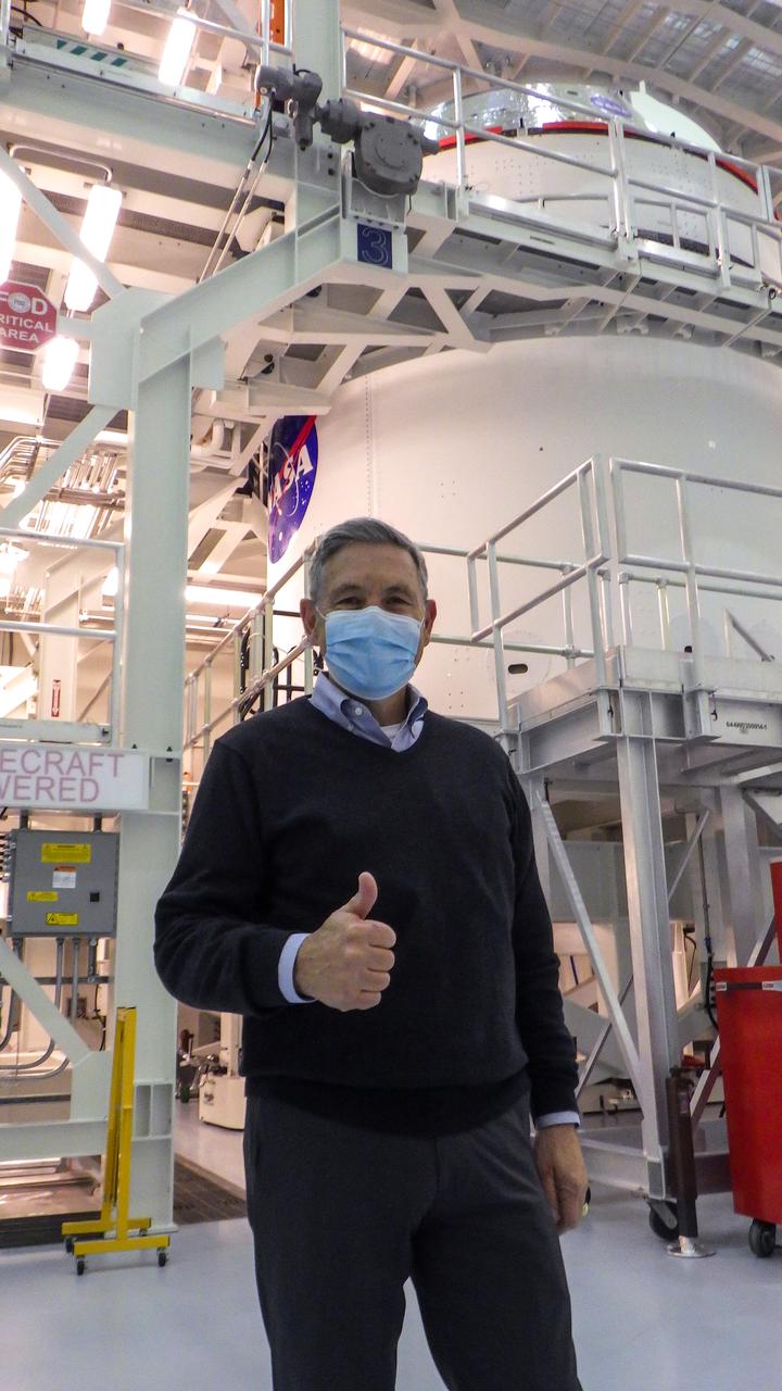 Kennedy Space Center Director Bob Cabana gives a thumbs up inside the Multi-Payload Processing Facility at the center on Jan. 20, 2021. Behind him is the Artemis I Orion spacecraft with NASA’s famous “meatball” insignia is affixed to the Artemis I Orion spacecraft adapter jettison fairings, which protect the European built service module. Shown inside its servicing stand, ground processing begins on Orion, with the Exploration Ground Systems and Jacobs teams performing checkouts and fueling the spacecraft with commodities as part of preparations ahead of the Artemis I mission.