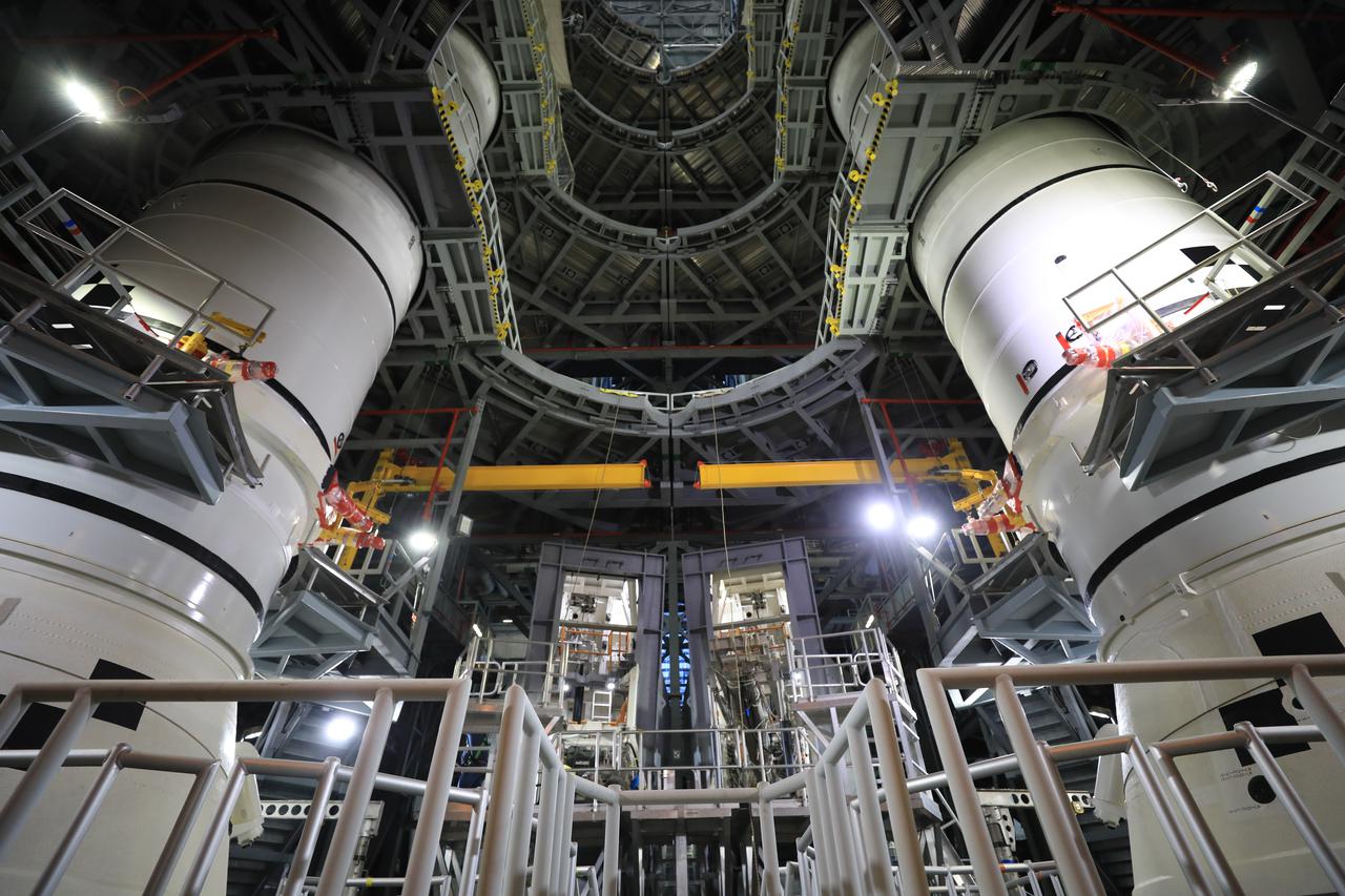 In High Bay 3 of the Vehicle Assembly Building at NASA’s Kennedy Space Center in Florida, the left-hand center center booster segment for Artemis I is lowered onto the center aft booster segment on the mobile launcher for the Space Launch System (SLS) on Jan. 21, 2021. Workers with Exploration Ground Systems and contractor Jacobs teams will stack the twin five-segment boosters on the mobile launcher in High Bay 3 over a number of weeks. When the core stage arrives, it will join the boosters on the mobile launcher, followed by the interim cryogenic propulsion stage and Orion spacecraft. Manufactured by Northrop Grumman in Utah, the twin boosters provide more than 75 percent of the total SLS thrust at launch. The SLS is managed by Marshall Space Flight Center in Huntsville, Alabama. Under the Artemis program, NASA will land the first woman and the next man on the Moon by 2024. The first in a series of increasingly complex missions, Artemis I will test the Orion spacecraft and SLS as an integrated system ahead of crewed flights to the Moon.