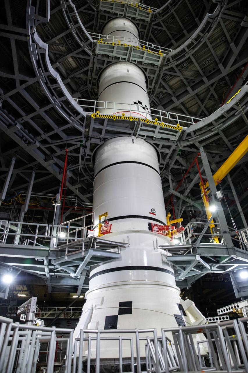 In High Bay 3 of the Vehicle Assembly Building at NASA’s Kennedy Space Center in Florida, the right-hand center center booster segment for Artemis I is lowered onto the center aft booster segment on the mobile launcher for the Space Launch System (SLS) on Jan. 26, 2021. Workers with Exploration Ground Systems and contractor Jacobs teams will stack the twin five-segment boosters on the mobile launcher in High Bay 3 over a number of weeks. When the core stage arrives, it will join the boosters on the mobile launcher, followed by the interim cryogenic propulsion stage and Orion spacecraft. Manufactured by Northrop Grumman in Utah, the twin boosters provide more than 75 percent of the total SLS thrust at launch. The SLS is managed by Marshall Space Flight Center in Huntsville, Alabama. Under the Artemis program, NASA will land the first woman and the next man on the Moon by 2024. The first in a series of increasingly complex missions, Artemis I will test the Orion spacecraft and SLS as an integrated system ahead of crewed flights to the Moon.