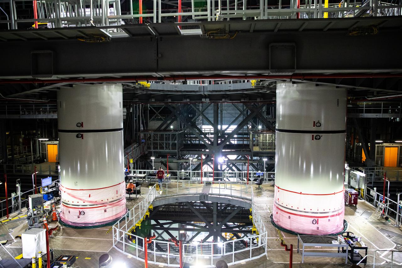 The twin boosters for NASA’s Space Launch System (SLS) for Artemis I are in view in High Bay 3 of the Vehicle Assembly Building at NASA’s Kennedy Space Center in Florida on Jan. 26, 2021. Work is in progress to lower the right-hand center center booster segment onto the center aft booster segment on the mobile launcher. Workers with Exploration Ground Systems and contractor Jacobs teams will stack the twin five-segment boosters on the mobile launcher in High Bay 3 over a number of weeks. When the core stage arrives, it will join the boosters on the mobile launcher, followed by the interim cryogenic propulsion stage and Orion spacecraft. Manufactured by Northrop Grumman in Utah, the twin boosters provide more than 75 percent of the total SLS thrust at launch. The SLS is managed by Marshall Space Flight Center in Huntsville, Alabama. Under the Artemis program, NASA will land the first woman and the next man on the Moon by 2024. The first in a series of increasingly complex missions, Artemis I will test the Orion spacecraft and SLS as an integrated system ahead of crewed flights to the Moon.