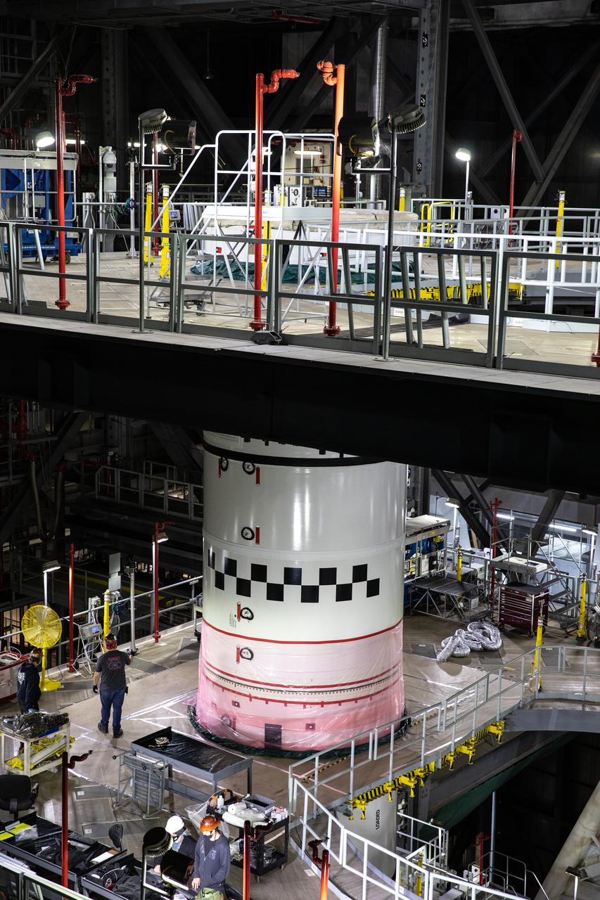 A close-up view in High Bay 3 of the Vehicle Assembly Building at NASA’s Kennedy Space Center in Florida, as the left-hand forward center booster segment for Artemis I is lowered onto the center center booster segment on the mobile launcher for the Space Launch System (SLS) on Jan. 29, 2021. Workers with Exploration Ground Systems and contractor Jacobs teams will stack the twin five-segment boosters on the mobile launcher in High Bay 3 over a number of weeks. When the core stage arrives, it will join the boosters on the mobile launcher, followed by the interim cryogenic propulsion stage and Orion spacecraft. Manufactured by Northrop Grumman in Utah, the twin boosters provide more than 75 percent of the total SLS thrust at launch. The SLS is managed by Marshall Space Flight Center in Huntsville, Alabama. Under the Artemis program, NASA will land the first woman and the next man on the Moon by 2024. The first in a series of increasingly complex missions, Artemis I will test the Orion spacecraft and SLS as an integrated system ahead of crewed flights to the Moon.