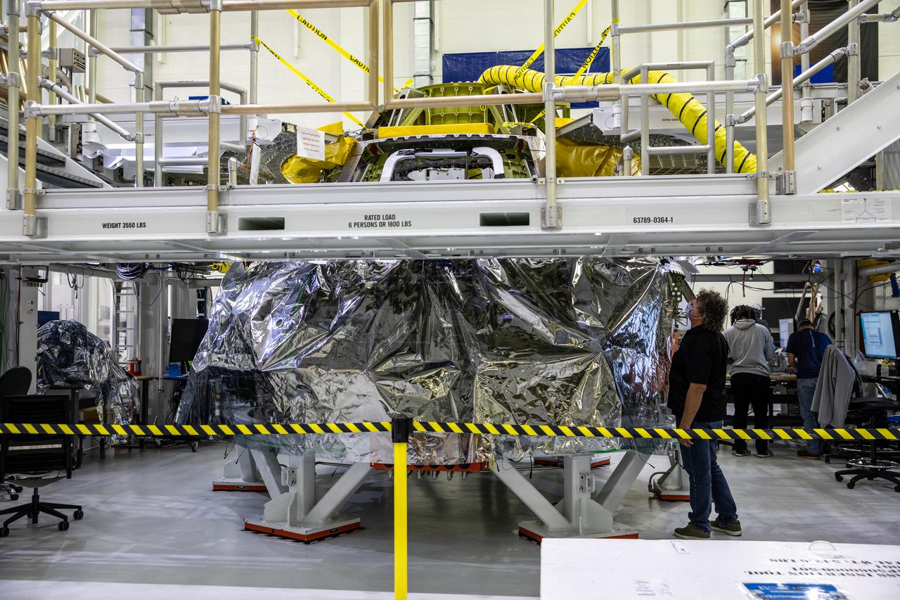 Workers inside the Neil Armstrong Operations and Checkout Building high bay at NASA's Kennedy Space Center in Florida, continue assembly of Orion’s Artemis II crew module on Feb. 5, 2021. The capsule will house astronauts during its mission around the Moon. Recently, teams removed the spacecraft from its clean room environment, where they have been performing the buildup of the Environmental Control and Propulsion System (ECPS) assemblies prior to their installation into the crew module. It will return to the clean room to complete ECPS final welds and assemblies. Artemis II will confirm all of the Orion spacecraft’s systems operate as designed in the actual environment of deep space with astronauts aboard. As part of the Artemis Program, NASA will send the first woman and next man to the Moon.