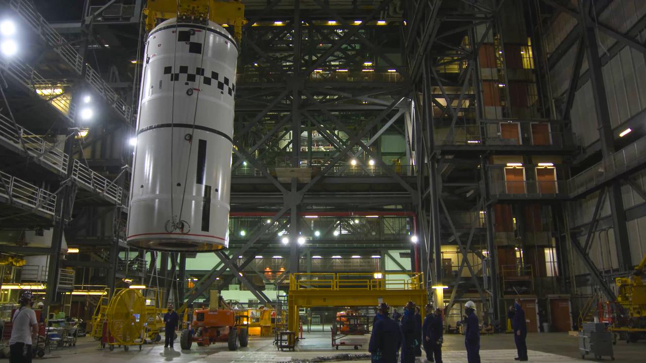 Workers use a crane to lift the left-hand forward segment up for transfer into High Bay 3 of the Vehicle Assembly Building for NASA’s Space Launch System (SLS) in the transfer aisle of the Vehicle Assembly Building at NASA’s Kennedy Space Center in Florida on Feb. 18, 2021. The forward segment will be attached to the center forward segment on the mobile launcher. Workers with Exploration Ground Systems and contractor Jacobs teams are stacking the twin five-segment boosters on the ML over a number of weeks. When the core stage arrives, it will join the boosters on the mobile launcher, followed by the interim cryogenic propulsion stage and Orion spacecraft. Manufactured by Northrop Grumman in Utah, the twin boosters provide more than 75 percent of the total SLS thrust at launch. The SLS is managed by Marshall Space Flight Center in Huntsville, Alabama. Under the Artemis program, NASA will land the first woman and the next man on the Moon by 2024. The first in a series of increasingly complex missions, Artemis I will test the Orion spacecraft and SLS as an integrated system ahead of crewed flights to the Moon.