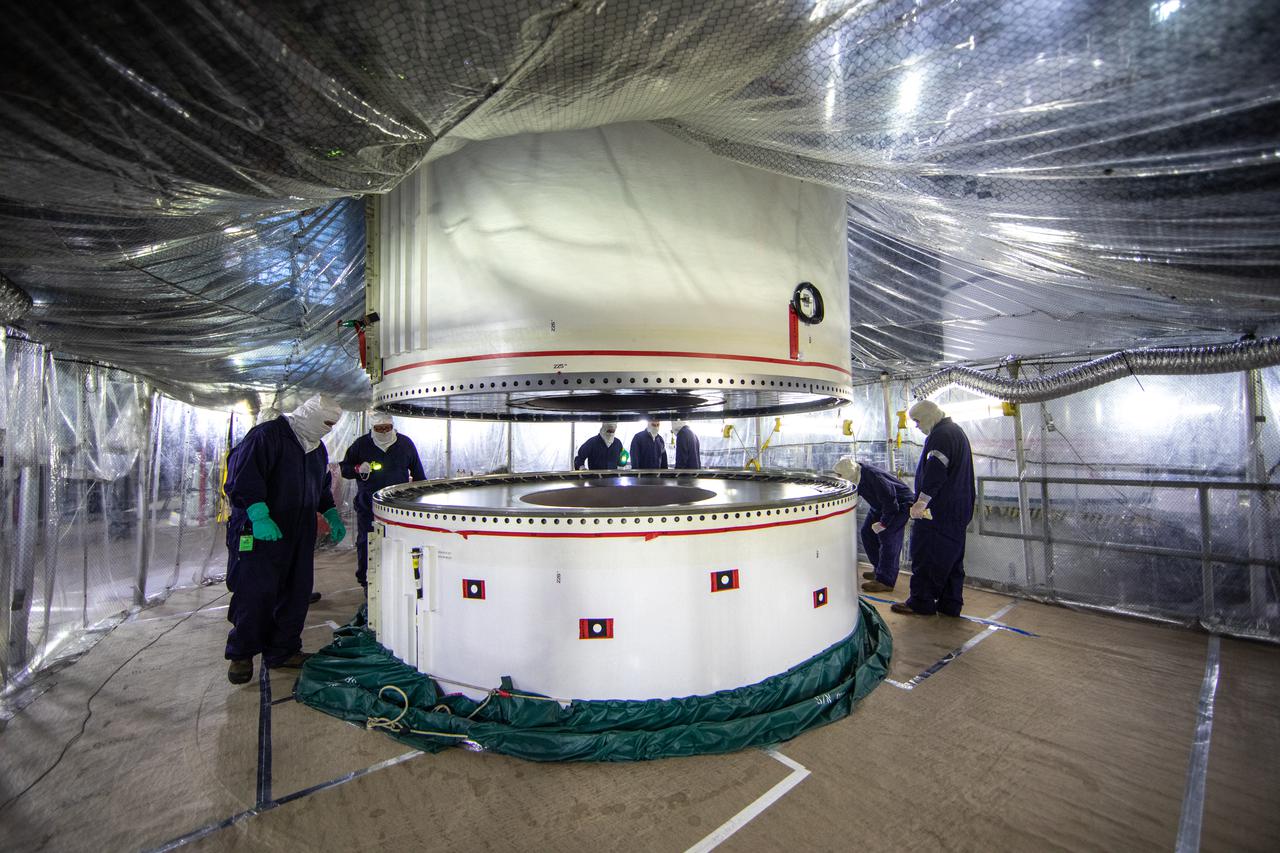 Workers with Exploration Ground Systems and contractor Jacobs teams assist as the right-hand forward segment for NASA’s Space Launch System (SLS) is lowered onto the center forward segment on the mobile launcher in High Bay 3 of the Vehicle Assembly Building at NASA’s Kennedy Space Center in Florida on Feb. 23, 2021. Stacking of the twin five-segment boosters on the mobile launcher is nearing completion. When the core stage arrives, it will join the boosters on the mobile launcher, followed by the interim cryogenic propulsion stage and Orion spacecraft. Manufactured by Northrop Grumman in Utah, the twin boosters provide more than 75 percent of the total SLS thrust at launch. The SLS is managed by Marshall Space Flight Center in Huntsville, Alabama. Under the Artemis program, NASA will land the first woman and the next man on the Moon by 2024. The first in a series of increasingly complex missions, Artemis I will test the Orion spacecraft and SLS as an integrated system ahead of crewed flights to the Moon.