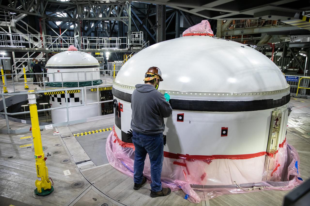 In High Bay 3 of the Vehicle Assembly Building at NASA’s Kennedy Space Center in Florida, a worker checks the right-hand forward segment on the center forward segment of the booster for Artemis I. The forward segments were lowered onto the twin solid rocket boosters on the mobile launcher (ML) for the Space Launch System (SLS) on Feb. 24, 2021. Workers with Exploration Ground Systems and contractor Jacobs teams are completing the stacking of the boosters. When the core stage arrives, it will join the boosters on the ML, followed by the interim cryogenic propulsion stage and Orion spacecraft. Manufactured by Northrop Grumman in Utah, the twin boosters provide more than 75 percent of the total SLS thrust at launch. The SLS is managed by Marshall Space Flight Center in Huntsville, Alabama. Under the Artemis program, NASA will land the first woman and the next man on the Moon by 2024. The first in a series of increasingly complex missions, Artemis I will test the Orion spacecraft and SLS as an integrated system ahead of crewed flights to the Moon.