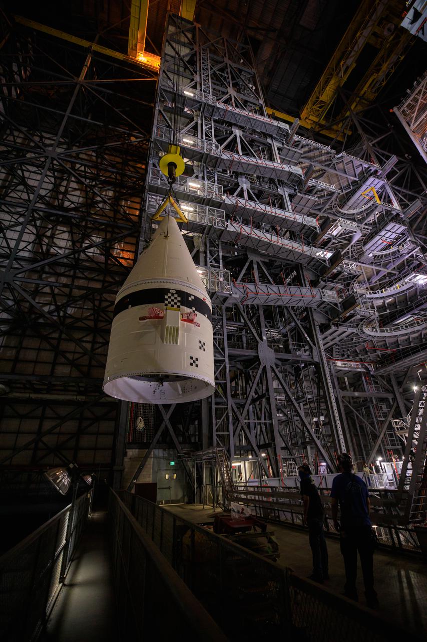 In the transfer aisle of the Vehicle Assembly Building at NASA’s Kennedy Space Center in Florida, workers use a crane to lift up the left-hand booster forward assembly for the agency’s Space Launch System for transfer into High Bay 3 on March 1, 2021. The forward assembly will be attached to the center forward segment on the mobile launcher (ML). Exploration Ground Systems and contractor Jacobs teams have been stacking the twin five-segment boosters on the ML over a number of weeks. When the core stage arrives, it will join the boosters on the mobile launcher, followed by the interim cryogenic propulsion stage and Orion spacecraft. Manufactured by Northrop Grumman in Utah, the twin boosters provide more than 75 percent of the total SLS thrust at launch. Marshall Space Flight Center in Huntsville, Alabama, manages the SLS. Under the Artemis program, NASA will land the first woman and the next man on the Moon. The first in a series of increasingly complex missions, Artemis I will test the Orion spacecraft and SLS as an integrated system ahead of crewed flights to the Moon.
