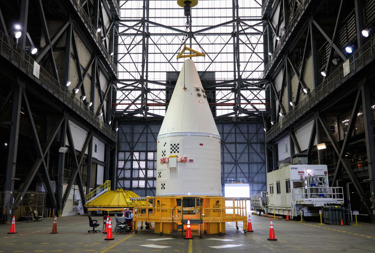 In the transfer aisle of the Vehicle Assembly Building at NASA’s Kennedy Space Center in Florida, workers use a crane to lift the right-hand forward assembly up for transfer into High Bay 3 for the Space Launch System (SLS) on March 2, 2021. The forward assembly will be attached to the center forward segment on the mobile launcher (ML). Workers with Exploration Ground Systems and contractor Jacobs teams are stacking the twin five-segment boosters on the ML over a number of weeks. When the core stage arrives, it will join the boosters on the mobile launcher, followed by the interim cryogenic propulsion stage and Orion spacecraft. Manufactured by Northrop Grumman in Utah, the twin boosters provide more than 75 percent of the total SLS thrust at launch. Marshall Space Flight Center in Huntsville, Alabama, manages the SLS. Under the Artemis program, NASA will land the first woman and the next man on the Moon. The first in a series of increasingly complex missions, Artemis I will test the Orion spacecraft and SLS as an integrated system ahead of crewed flights to the Moon.