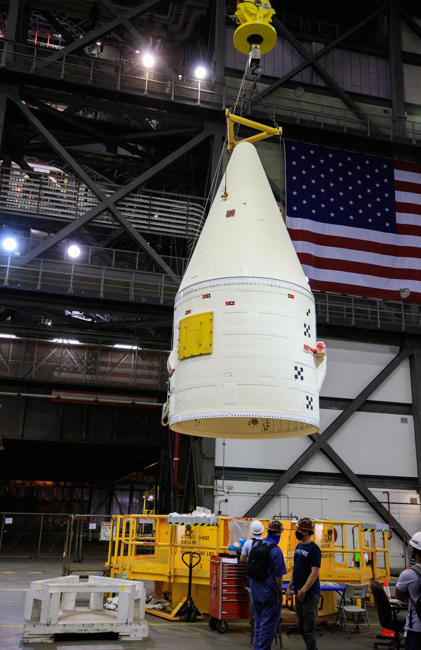 In the transfer aisle of the Vehicle Assembly Building at NASA’s Kennedy Space Center in Florida, workers use a crane to lift the right-hand forward assembly up for transfer into High Bay 3 for the Space Launch System (SLS) on March 2, 2021. The forward assembly will be attached to the center forward segment on the mobile launcher (ML). Workers with Exploration Ground Systems and contractor Jacobs teams are stacking the twin five-segment boosters on the ML over a number of weeks. When the core stage arrives, it will join the boosters on the mobile launcher, followed by the interim cryogenic propulsion stage and Orion spacecraft. Manufactured by Northrop Grumman in Utah, the twin boosters provide more than 75 percent of the total SLS thrust at launch. Marshall Space Flight Center in Huntsville, Alabama, manages the SLS. Under the Artemis program, NASA will land the first woman and the next man on the Moon. The first in a series of increasingly complex missions, Artemis I will test the Orion spacecraft and SLS as an integrated system ahead of crewed flights to the Moon.
