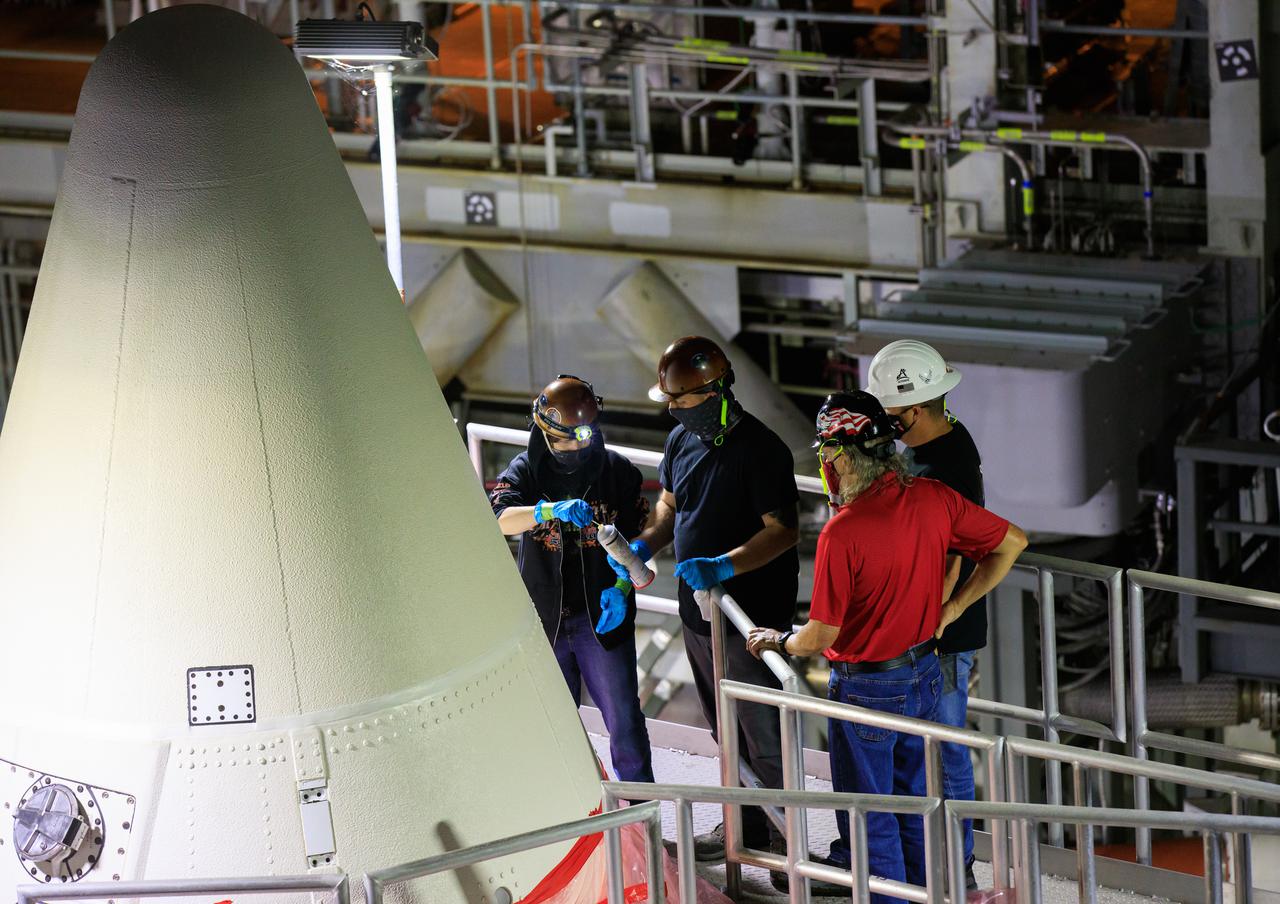 In High Bay 3 of the Vehicle Assembly Building at NASA’s Kennedy Space Center in Florida, workers assist as the right-hand forward segment is lowered onto the center forward segment on the mobile launcher (ML) for the Space Launch System (SLS) on March 3, 2021. Workers with Exploration Ground Systems and contractor Jacobs teams stacked the twin five-segment boosters on the ML over a number of weeks. When the core stage arrives, it will join the boosters on the mobile launcher, followed by the interim cryogenic propulsion stage and Orion spacecraft. Manufactured by Northrop Grumman in Utah, the twin boosters provide more than 75 percent of the total SLS thrust at launch. Marshall Space Flight Center in Huntsville, Alabama, manages the SLS. Under the Artemis program, NASA will land the first woman and the next man on the Moon. The first in a series of increasingly complex missions, Artemis I will test the Orion spacecraft and SLS as an integrated system ahead of crewed flights to the Moon.