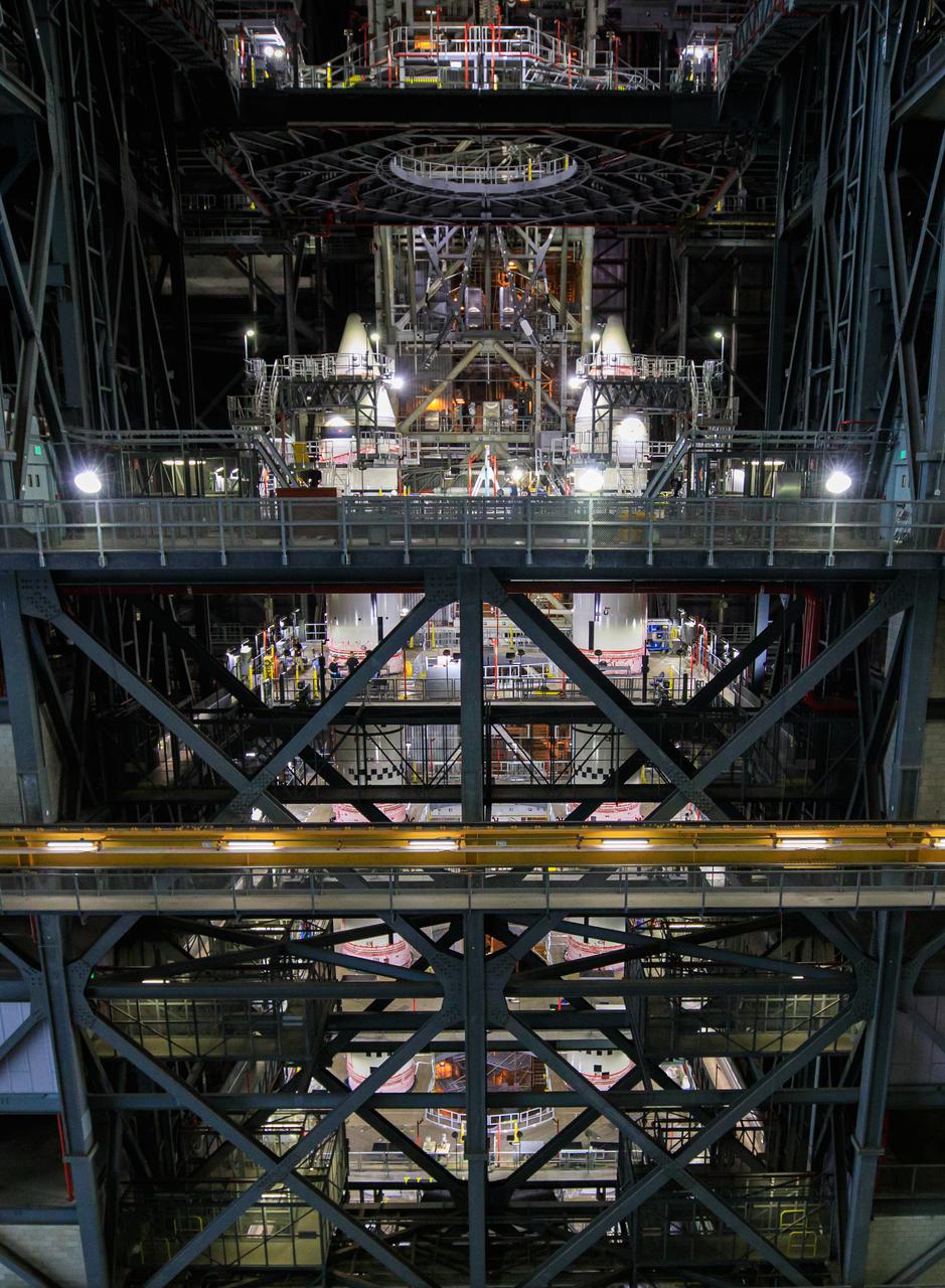 In High Bay 3 of the Vehicle Assembly Building at NASA’s Kennedy Space Center in Florida, the right-hand and left-hand forward segments are secured on the center forward segments on the mobile launcher (ML) for the Space Launch System (SLS) on March 3, 2021. Workers with Exploration Ground Systems and contractor Jacobs teams stacked the twin five-segment boosters on the ML over a number of weeks. When the core stage arrives, it will join the boosters on the mobile launcher, followed by the interim cryogenic propulsion stage and Orion spacecraft. Manufactured by Northrop Grumman in Utah, the twin boosters provide more than 75 percent of the total SLS thrust at launch. Marshall Space Flight Center in Huntsville, Alabama, manages the SLS. Under the Artemis program, NASA will land the first woman and the next man on the Moon. The first in a series of increasingly complex missions, Artemis I will test the Orion spacecraft and SLS as an integrated system ahead of crewed flights to the Moon.