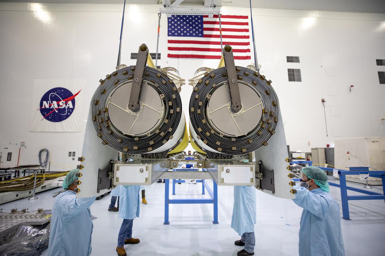 NASA and Boeing workers help position the solar arrays onto flight support equipment inside the high bay of the Space Station Processing Facility at NASA’s Kennedy Space Center in Florida on April 2, 2021. The 63- by- 20-foot solar arrays will launch to the International Space Station later this year. They are the first two of six new solar arrays that in total will produce more than 120 kilowatts of electricity from the Sun’s energy, enough to power more than 40 average U.S. homes. Combined with the eight original, larger arrays, this advanced hardware will provide 215 kilowatts of energy, a 20 to 30 percent increase in power, helping maximize the space station’s capabilities for years to come. The arrays will produce electricity to sustain the station’s systems and equipment, plus augment the electricity available to continue a wide variety of public and private experiments and research in the microgravity environment of low-Earth orbit.